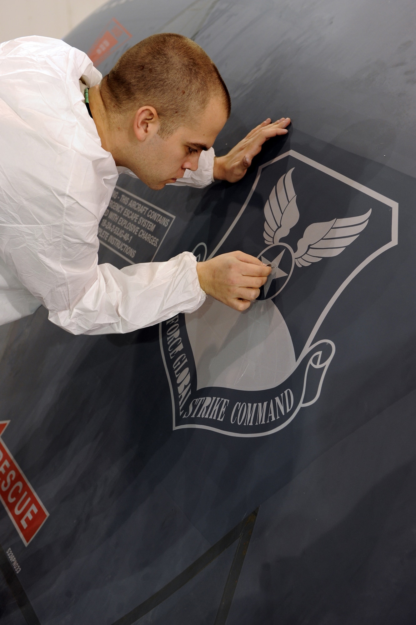 WHITEMAN AIR FORCE BASE, Mo. -Senior Airman Benjamin Seegraves, 509th Maintenance Squadron structural maintenance technician, removes the more technical pieces of the Air Force Global Strike Command patch stencil that replaced the Air Combat Command patch, Jan. 25, 2010. On Feb. 1, 2010, Whiteman AFB and its arsenal of 20 B-2 bombers will change commands from ACC to AFGSC. The mission of AFGSC is to "develop and provide combat-ready forces for nuclear deterrence and global strike operations -- safe -- secure -- credible to support the President of the United States and combatant commanders." (U.S. Air Force photo by Airman 1st Class Carlin Leslie) (Released) 