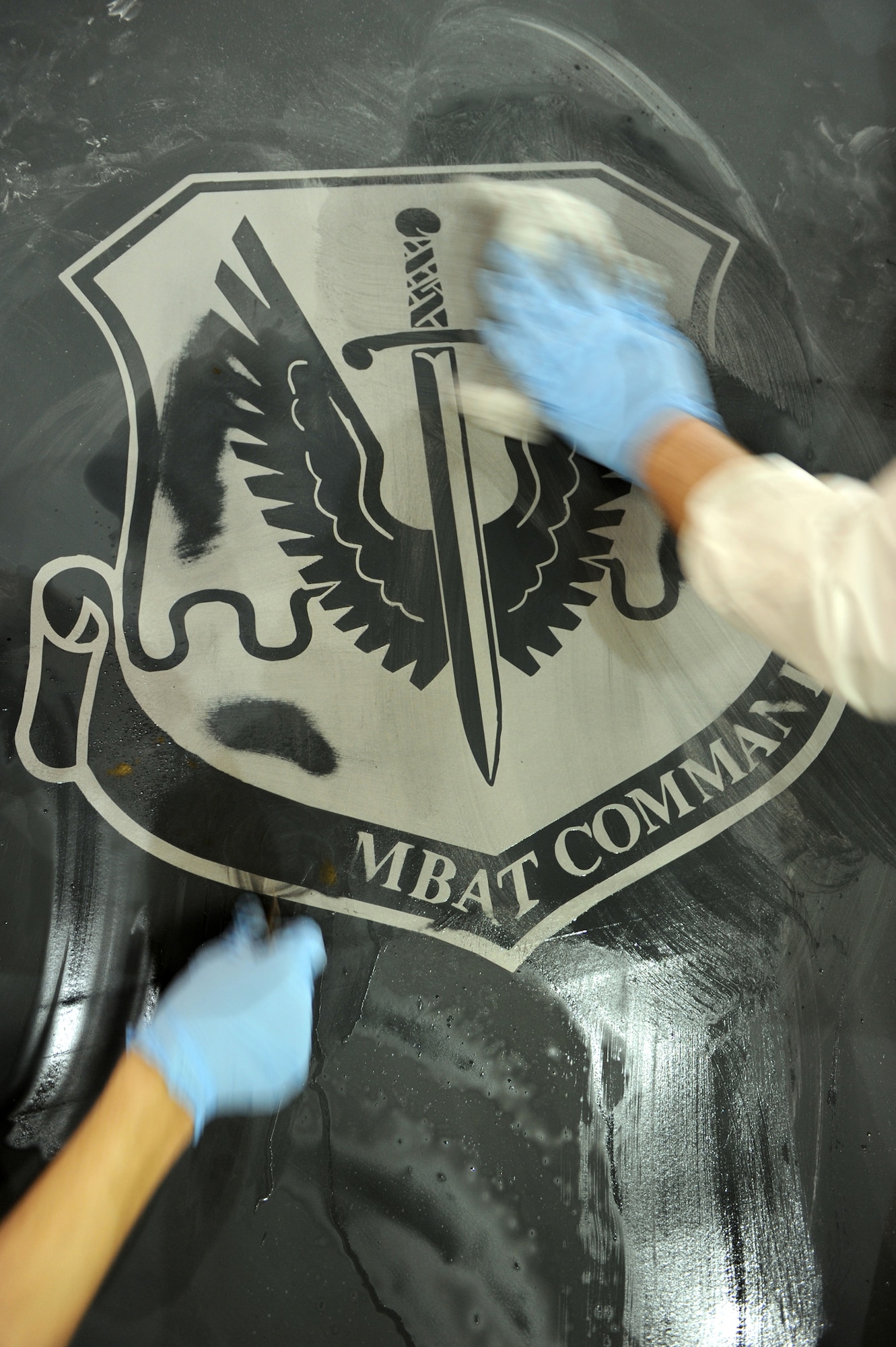 WHITEMAN AIR FORCE BASE, Mo. - Senior Airman Donald Curran and Senior Airman Randolph Tilton, 509th Maintenance Squadron structural maintenance technicians, use a small ammount of fluid to remove the Air Combat Command patch from a B-2, Jan. 25, 2010. On Feb. 1, 2010, Whiteman AFB and its arsenal of 20 B-2 bombers will change commands from ACC to Air Force Global Strike Command. The mission of AFGSC is to "develop and provide combat-ready forces for nuclear deterrence and global strike operations -- safe -- secure -- credible to support the President of the United States and combatant commanders." (U.S. Air Force photo by Airman 1st Class Carlin Leslie) (Released)