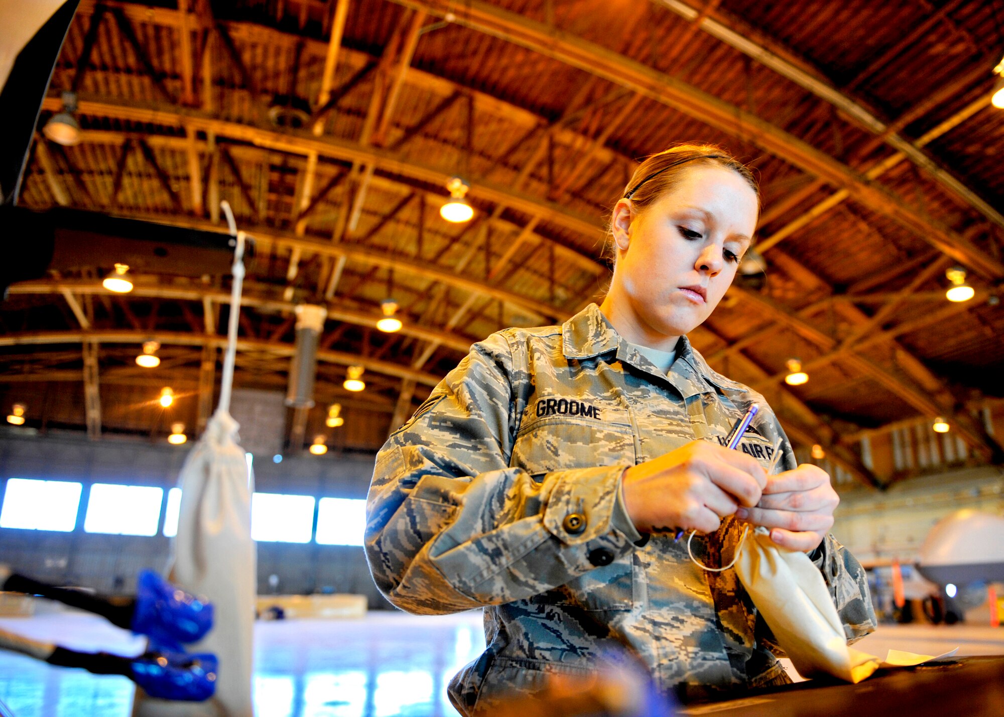 HOLLOMAN AIR FORCE BASE, N.M. -- Senior Airman Stephanie Groome, a crew chief assigned to the 849th Aircraft Maintenance Squadron, puts hardware into a bag, labels it and assigns it to the correct wing to ensure the hardware isn't lost during transportation Jan 17. Team Holloman prepared personnel and two RQ-1 Predators to send to Haiti after it was rocked by a 7.0-magnitude earthquake, Jan. 12. (U.S. Air Force photo by Staff Sgt. Anthony Nelson Jr.)