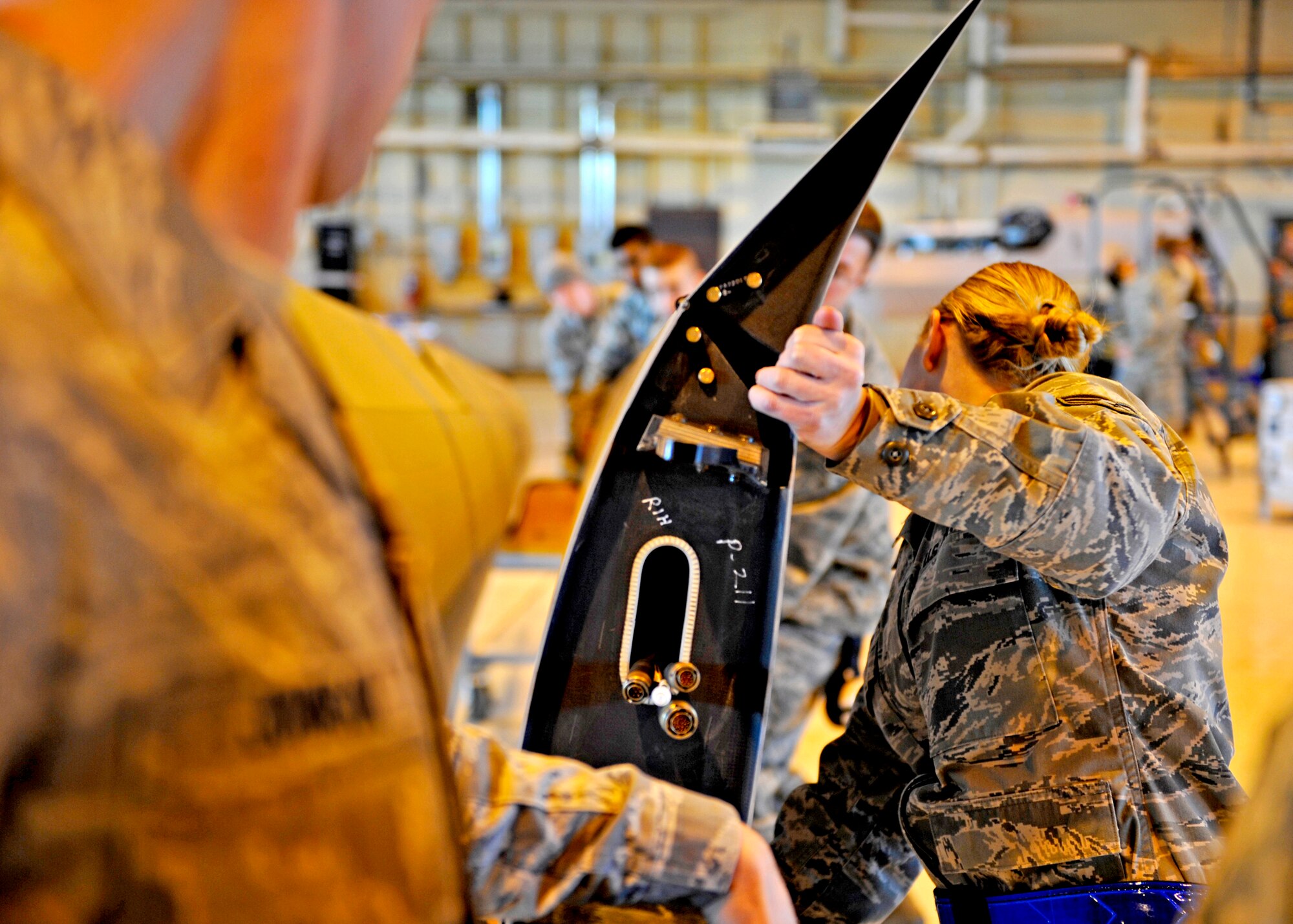 HOLLOMAN AIR FORCE BASE, N.M. -- Senior Airman Stephanie Groome, a crew chief assigned to the 849th Aircraft Maintenance Squadron, assists with placing the right wing of the RQ-1 Predator into a casket for transportation, Jan 17. Airmen were disassembling and packaging an RQ-1 for departure in support of Operation Unified Response. (U.S. Air Force photo by Staff Sgt. Anthony Nelson Jr.)
