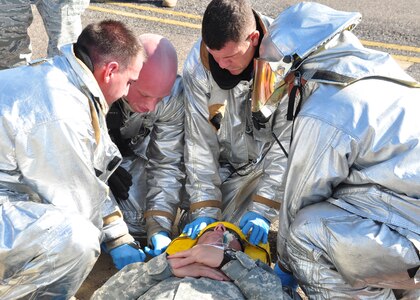Team Soto Cano firefighters conduct lifesaving procedures and prep mock crash victim for transport during a major accident response exercise Jan. 22 on the Soto Cano AB, Honduras flightline. Agencies from across Soto Cano AB participated in the MAREX to evaluated their response procedures and improve their skill sets. (U.S. Air Force photo/Staff Sgt. Bryan Franks)