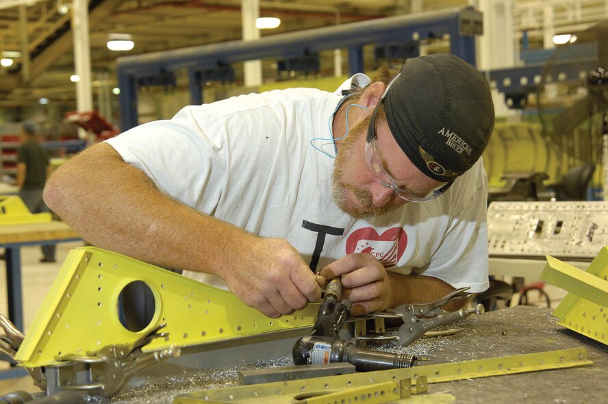 Robert Daniels of the 551st Commodities Maintenance Squadron at Tinker AFB, Okla., drills holes for rivets while changing KC-135 spoiler ribs.  The Civilian Career Development Program for depot maintenance workers at Air Force Materiel Command’s Air Logistics Centers can be used as a mapping tool to broaden careers for those unable to utilize computers every day. (File photo/ Margo Wright)