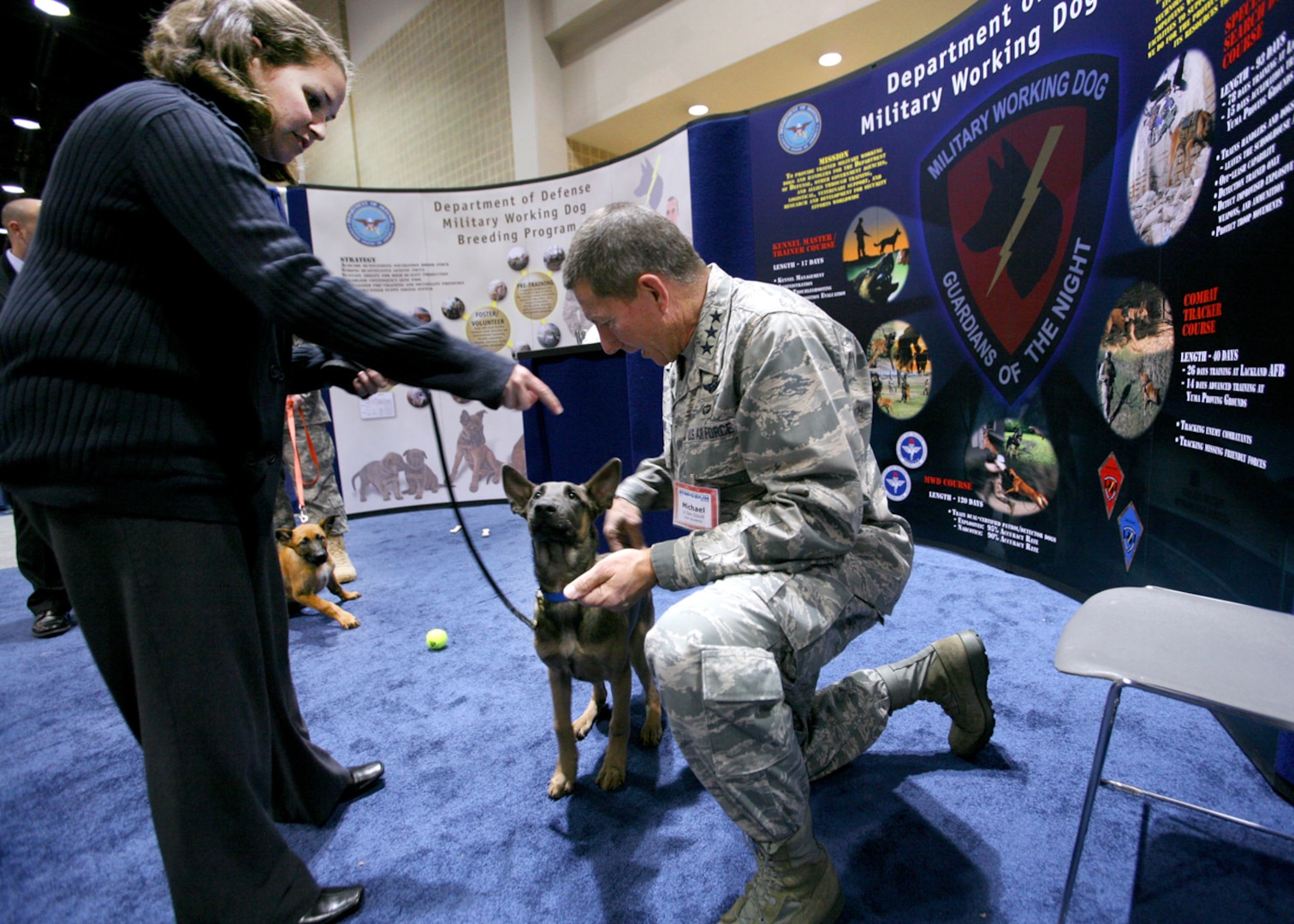 Lt. Gen. Michael Gould, Air Force Academy Superintendent, says hello to Jjet at the 2010 Air Education and Training Command symposium Jan. 14 while Lynnette Butler explains the Department of Defense military working dog breeding program. The symposium featured nearly 100 academic seminars on a variety of Air Force topics. (U.S. Air Force photo/Robbin Cresswell)