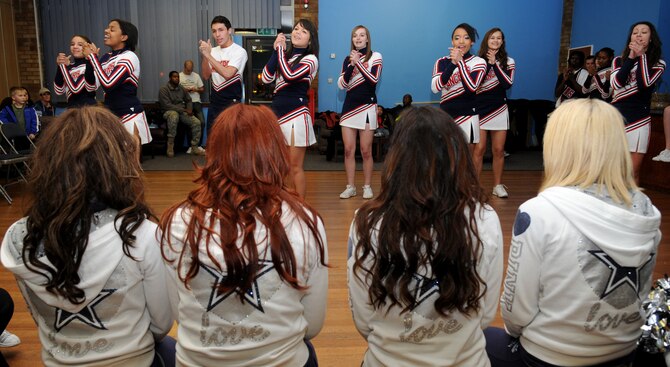 RAF MILDENHALL, England – Four Dallas Cowboys Cheerleaders watch as the Lakenheath High School varsity cheerleading squad perform a routine at the Bob Hope Community Center Jan. 25. (U.S. Air Force Photo/ Staff Sgt. Jerry Fleshman)