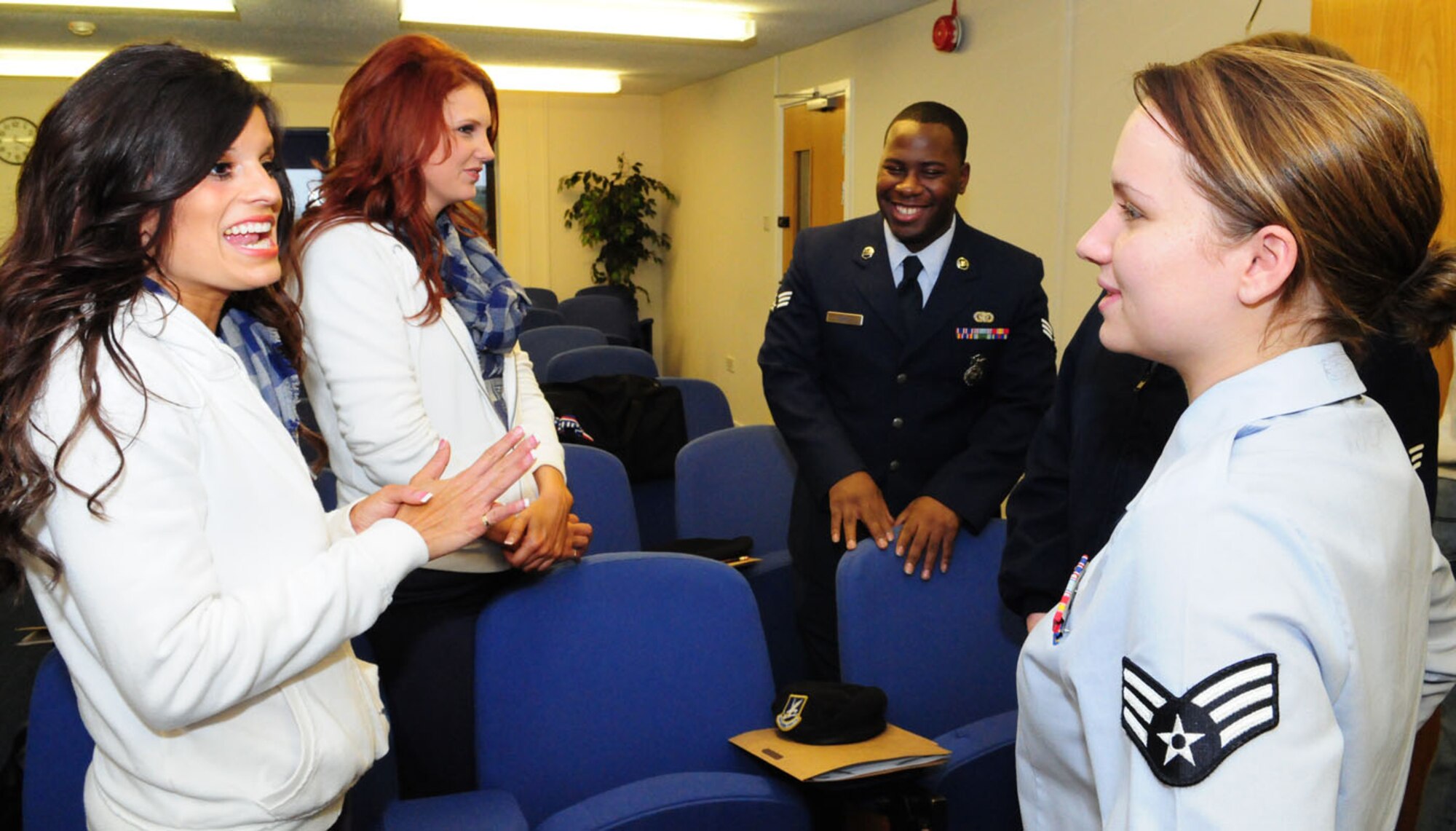RAF MILDENHALL, England – Trisha Trevino, left, and Meredith Oden, second left, two of the Dallas Cowboys cheerleaders, chat with Senior Airman Norris Shaw and Senior Airman Brittany Townsend, right, 100th Security Forces Squadron, when the cheerleaders and country singer Neal McCoy visited RAF Mildenhall Jan. 25. The performers were here as part of a United Services Organization tour for the troops. (U.S. Air Force photo by Karen Abeyasekere)