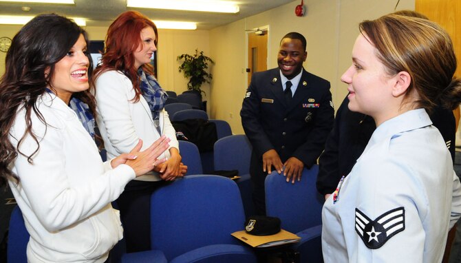 RAF MILDENHALL, England – Trisha Trevino, left, and Meredith Oden, second left, two of the Dallas Cowboys cheerleaders, chat with Senior Airman Norris Shaw and Senior Airman Brittany Townsend, right, 100th Security Forces Squadron, when the cheerleaders and country singer Neal McCoy visited RAF Mildenhall Jan. 25. The performers were here as part of a United Services Organization tour for the troops. (U.S. Air Force photo by Karen Abeyasekere)