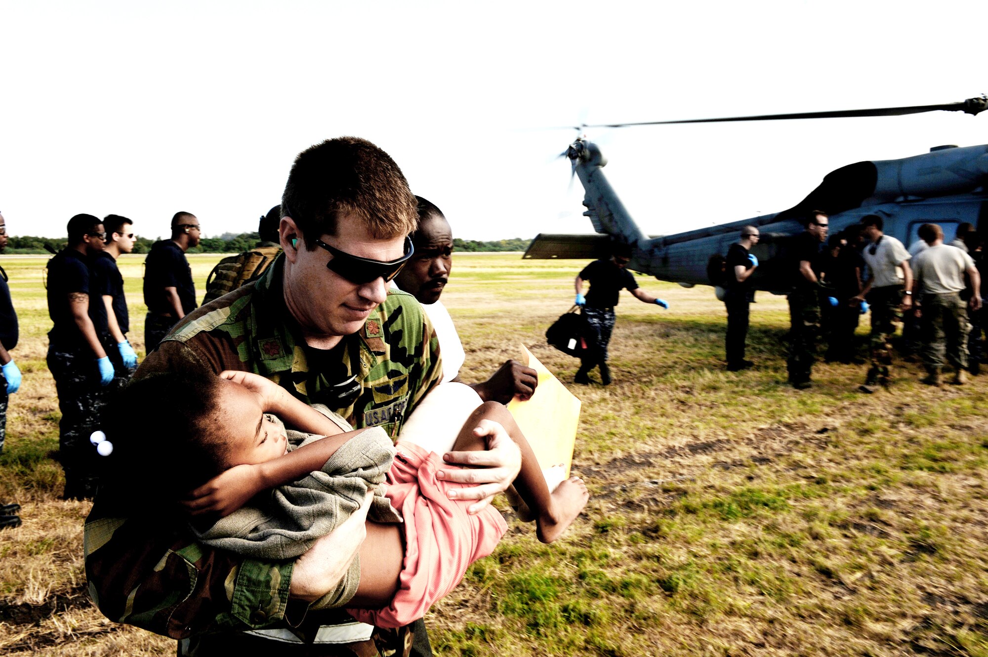 Maj. Timothy Ballard carries a 6-year-old boy from a helicopter to a field clinic Jan 19, 2010, at the Toussaint L'Ouverture International Airport in Port-au-Prince, Haiti. Later, the boy was airlifted to a stateside hospital in southern Florida. Major Ballard is with the 1st Special Operations Support Squadron at Hurlburt Field, Fla. (U.S. Air Force photo/Tech. Sgt. James L. Harper Jr.)