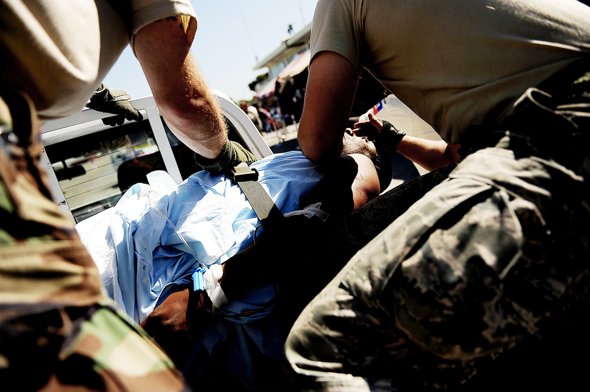 Master Sgt. Douglas Brook and Tech. Sgt. Nicholas Wentworth perform urgent medical care on a Haitian man at the Toussaint L'Ouverture International Airport Jan. 18, 2010, in Port-au-Prince, Haiti. The man was injured in the Jan. 12 7.0-magnitude earthquake. Sergeants Brook and Wentworth are both assigned to the 1st Special Operations Support Squadron. (U.S. Air Force photo/Master Sgt. Jeremy Lock)