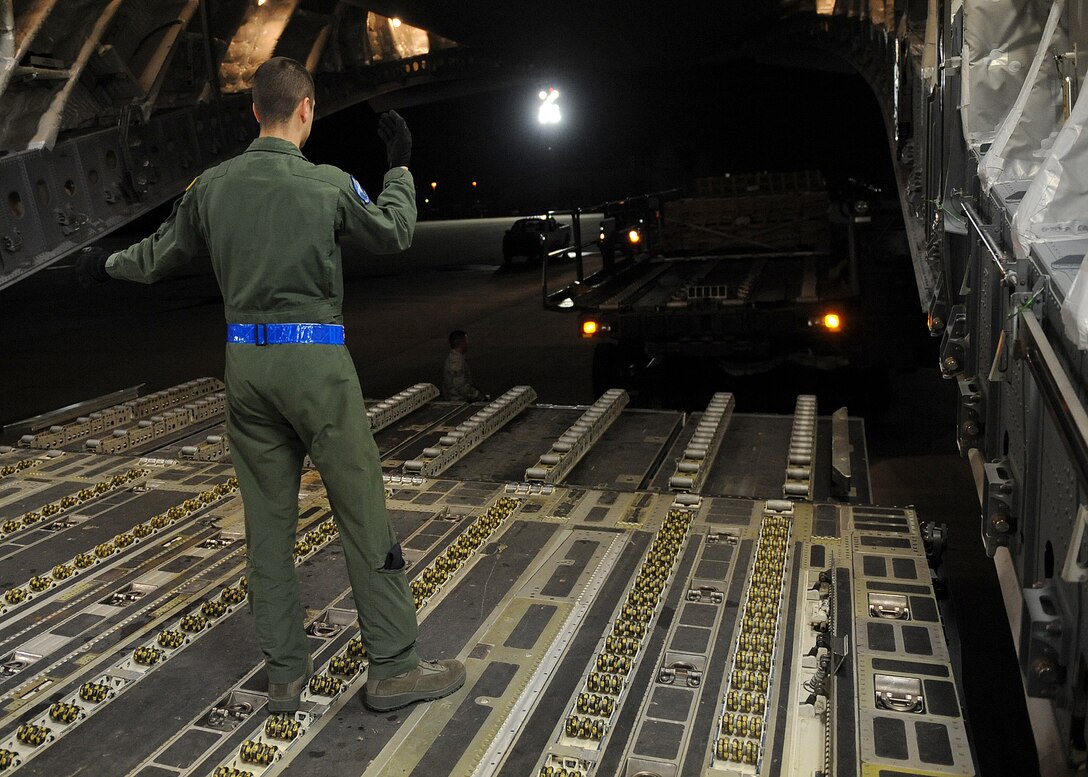 LANGLEY AIR FORCE BASE, Va. – Airman 1st Class Alec Parker, 7th Airlift Squadron loadmaster from McChord Air Force Base, Wash., guides a supply-filled vehicle up to the bay of a C-17 Globemaster III Jan. 22 in support Operation Unified Response, a massive movement of military personnel and supplies to aid in relief efforts following the devastating earthquake that struck Haiti on Jan. 12. Langley Airmen and U.S. Army personnel from Fort Eustis helped McChord Airmen load equipment and supplies onto the aircraft, the third of its type to transfer Peninsula efforts. (U.S. Air Force photo/ Airman Rebecca Montez)
