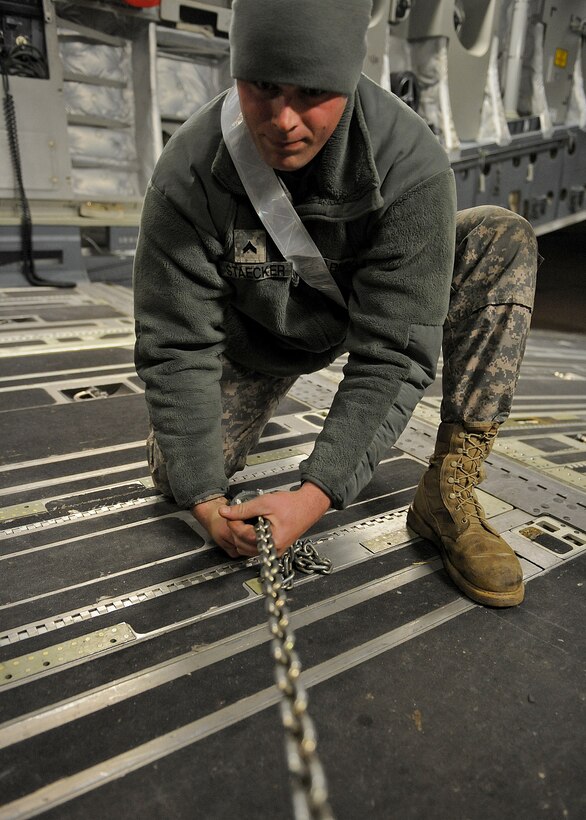 LANGLEY AIR FORCE BASE, Va. – U.S. Army Cpl. Matthew Staecker, 24th Transportation Battalion from Fort Eustis, uses chains to help secure equipment to a C-17 Globemaster III Jan. 22 in support Operation Unified Response, a massive movement of military personnel and supplies to aid in relief efforts following the devastating earthquake that struck Haiti on Jan. 12.  Langley Airmen and U.S. Army personnel from Fort Eustis loaded equipment and supplies onto the aircraft, the third of its type to transfer Peninsula efforts. (U.S. Air Force photo/ Airman Rebecca Montez)
