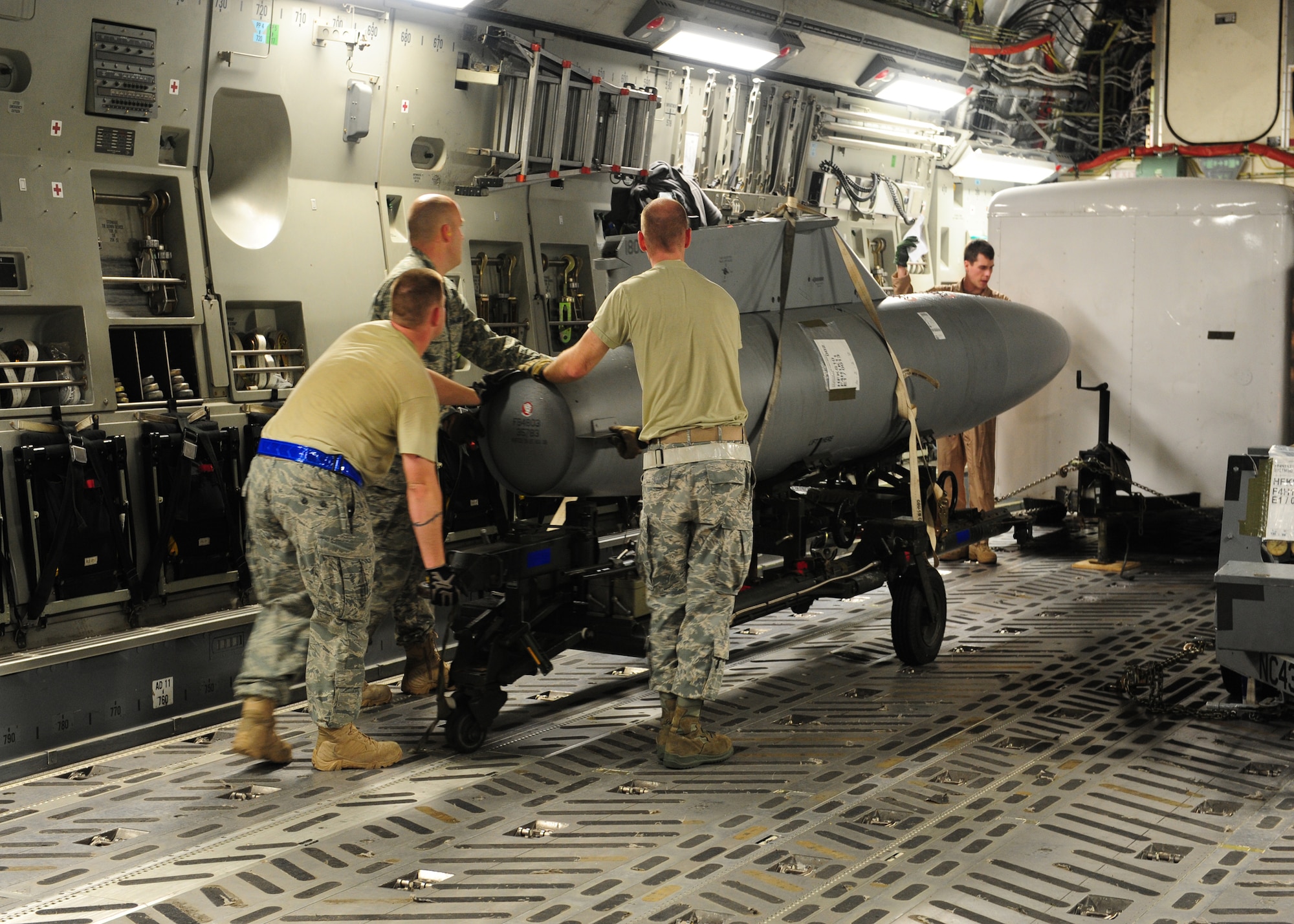 SHAW AIR FORCE BASE, S.C. -- Airmen of the 16th Airlift Squadron, Charleston Air Force Base, S.C., and the 20th Logistics Readiness Squadron position an F-16 pod in the cargo compartment of a C-17 Jan. 24.  The equipment, which belongs to the 77th Fighter Squadron, is headed to Iraq in support of their ongoing deployment. The cargo must be strategically positioned to ensure safety of flight, optimize weight distribution and maximize fuel efficiency. (U.S. Air Force photo/2nd Lt. Tony Richardson)