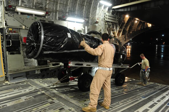 SHAW AIR FORCE BASE, S.C. -- Senior Airman Alexander Logan (left), 16th Airlift Squadron loadmaster, Charleston Air Force Base, S.C., and Staff Sgt. Chris Deibel, 20th Logistics Readiness Squadron air transportation specialist, check for possible obstructions as they safely guide an F-16 engine into the cargo bay of a C-17 Jan. 24. The equipment, which belongs to the 77th Fighter Squadron, is headed to Iraq in support of their ongoing deployment. (U.S. Air Force photo/2nd Lt. Tony Richardson)