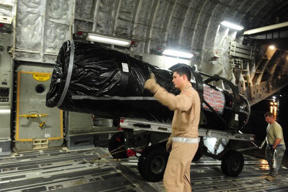SHAW AIR FORCE BASE, S.C. -- Senior Airman Alexander Logan (left), 16th Airlift Squadron loadmaster, Charleston Air Force Base, S.C., and Staff Sgt. Chris Deibel, 20th Logistics Readiness Squadron air transportation specialist, safely guide an F-16 engine into the cargo bay of a C-17 Jan. 24. The equipment, which belongs to the 77th Fighter Squadron, is headed to Iraq in support of their ongoing deployment. (U.S. Air Force photo/2nd Lt. Tony Richardson)