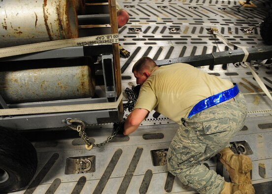SHAW AIR FORCE BASE, S.C. -- Staff Sgt. Chris Deibel, 20th Logistics Readiness Squadron air transportation specialist, uses chains to secure a nitrogen cart to the floor of a C-17 Jan. 24. The equipment, which belongs to the 77th Fighter Squadron, is headed to Iraq in support of their ongoing deployment. (U.S. Air Force photo/2nd Lt. Tony Richardson)