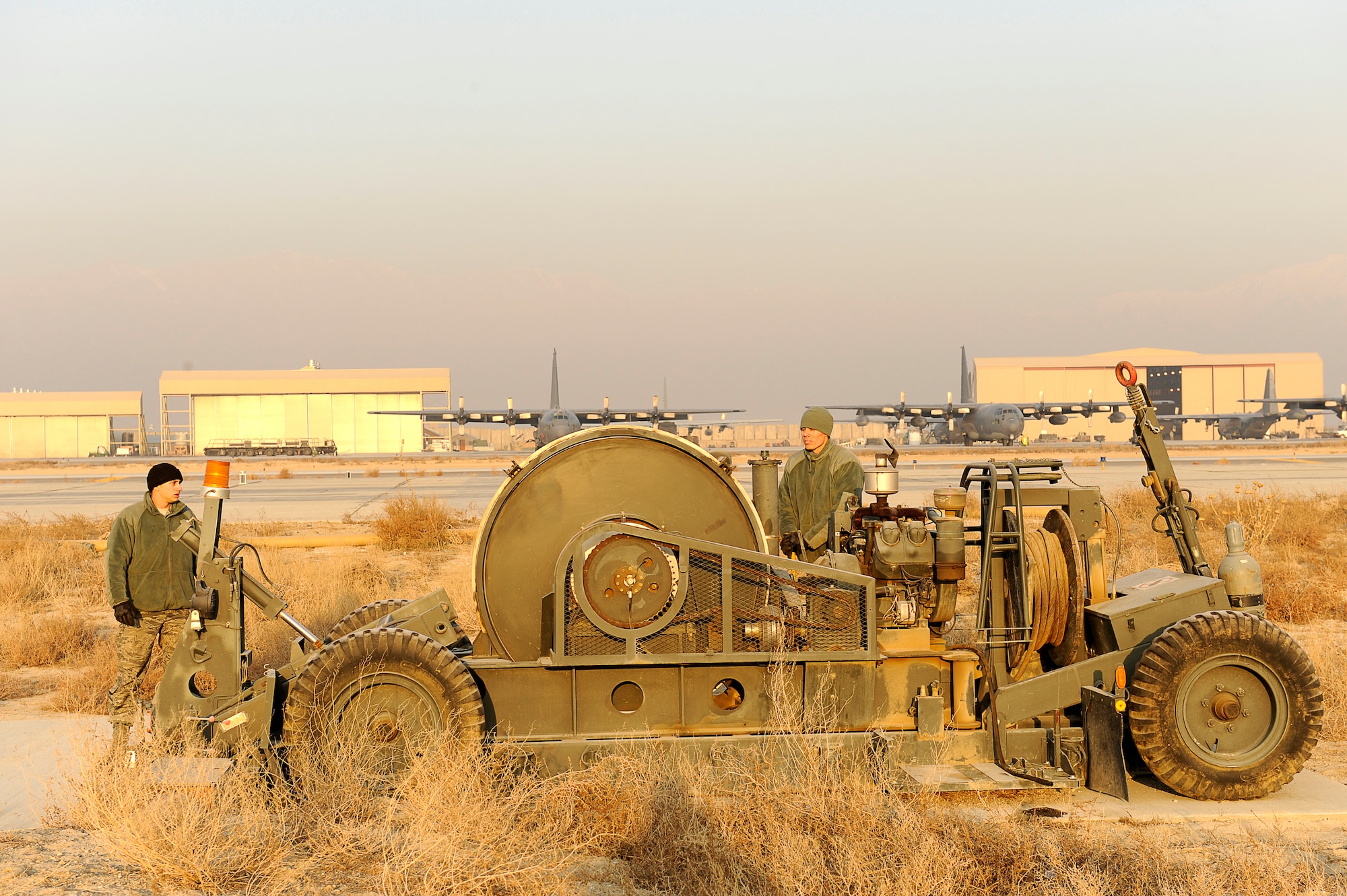 BAGRAM AIRFIELD, Afghanistan--U.S. Air Force Airman 1st Class Dustin Bartlett (left), and Senior Airman Edwin Brown, 455th Expeditionary Civil Engineer Squadron, operate an arresting cable motor at Bagram Airfield, Jan. 15, 2010. Bartlett is from Duluth, Minn., and Brown is from Maple, Wis., both are members of the Minnesota National Guard. (U.S. Air Force photo by: Tech. Sgt. Jeromy K. Cross)