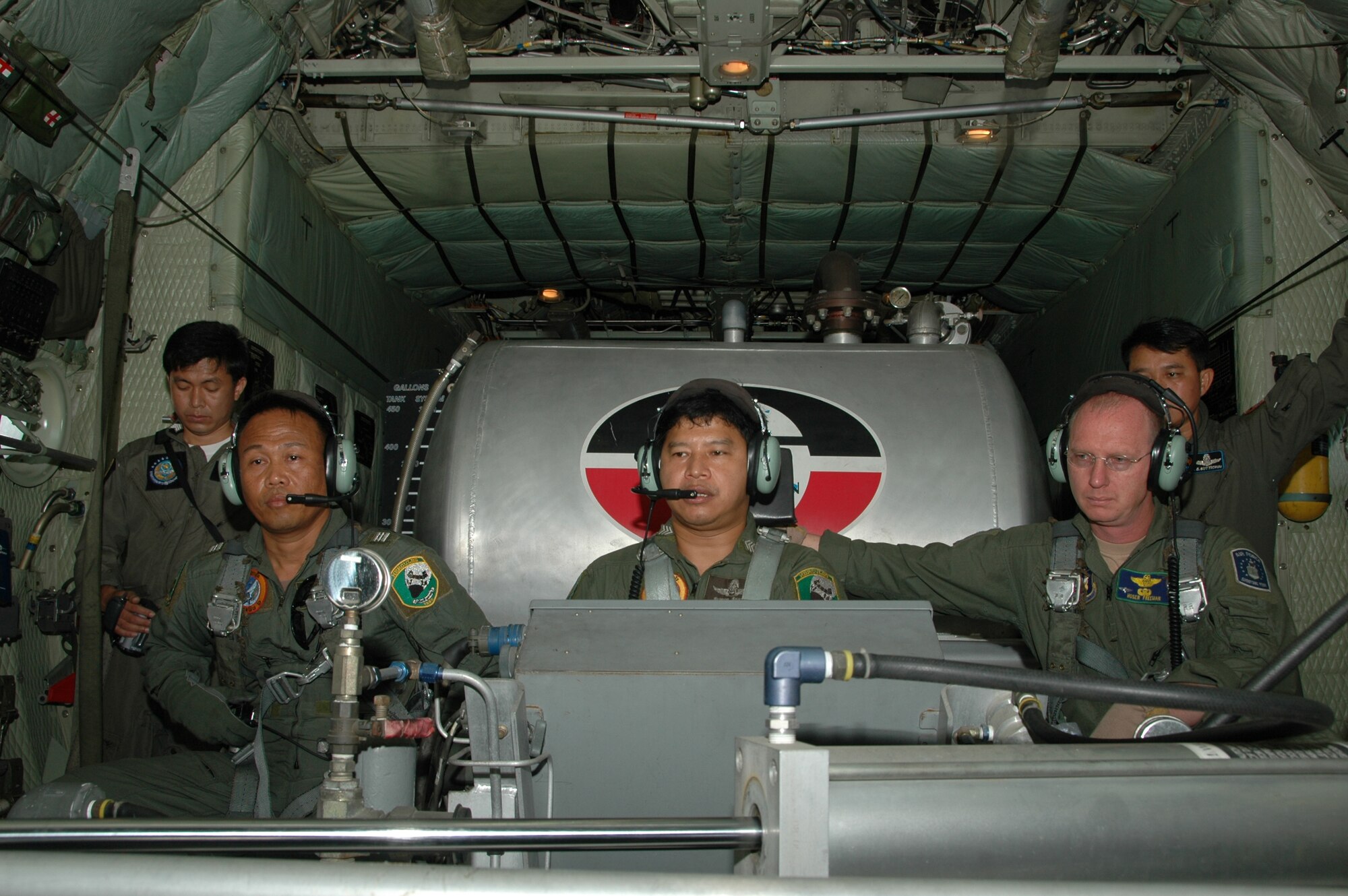 Master Sgt. Tom T. Freeman, loadmaster with the Air Force Reserve’s 302nd Airlift Wing based at Peterson AFB, Colo., looks on as Royal Thai Air Force members complete checklists for the Modular Airborne Firefighting System at Phitsanulok Royal Thai Air Force Base, Thailand.  Seven members of the 302 AW traveled to Thailand to provide expert training to RTAF members on safe and effective Modular Airborne Firefighting System operations.  This event marks the first time the Air Force Reserve has sent delegates to train a foreign Air Force on use of the MAFFS equipment. (U.S. Air Force photo/Capt. Jody L. Ritchie)