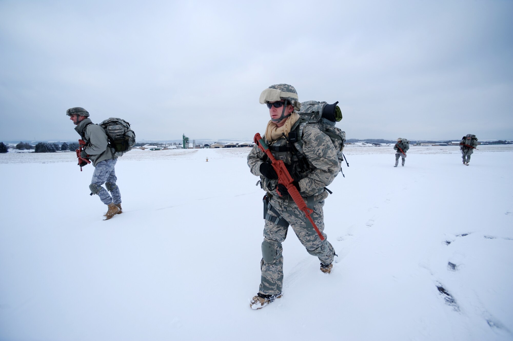 U.S. Air Force Capt. Mark Breed, 435th Security Forces Squadron, operations officer, and Staff Sgt. John Gaunt, Sembach Annex, Germany, maneuvers toward a rally point after an airborne insertion mission, Flugplatz Bitburg, Germany, Jan. 25, 2010, in preparation of Ramstein's operational readiness inspection in September. The unit is setting up bare-base operations as part of the dual-wing operational readiness exercise with the 86th Airlift Wing. This is the second of five operational readiness exercises. (U.S. Air Force photo by Staff Sgt. Sarayuth Pinthong)