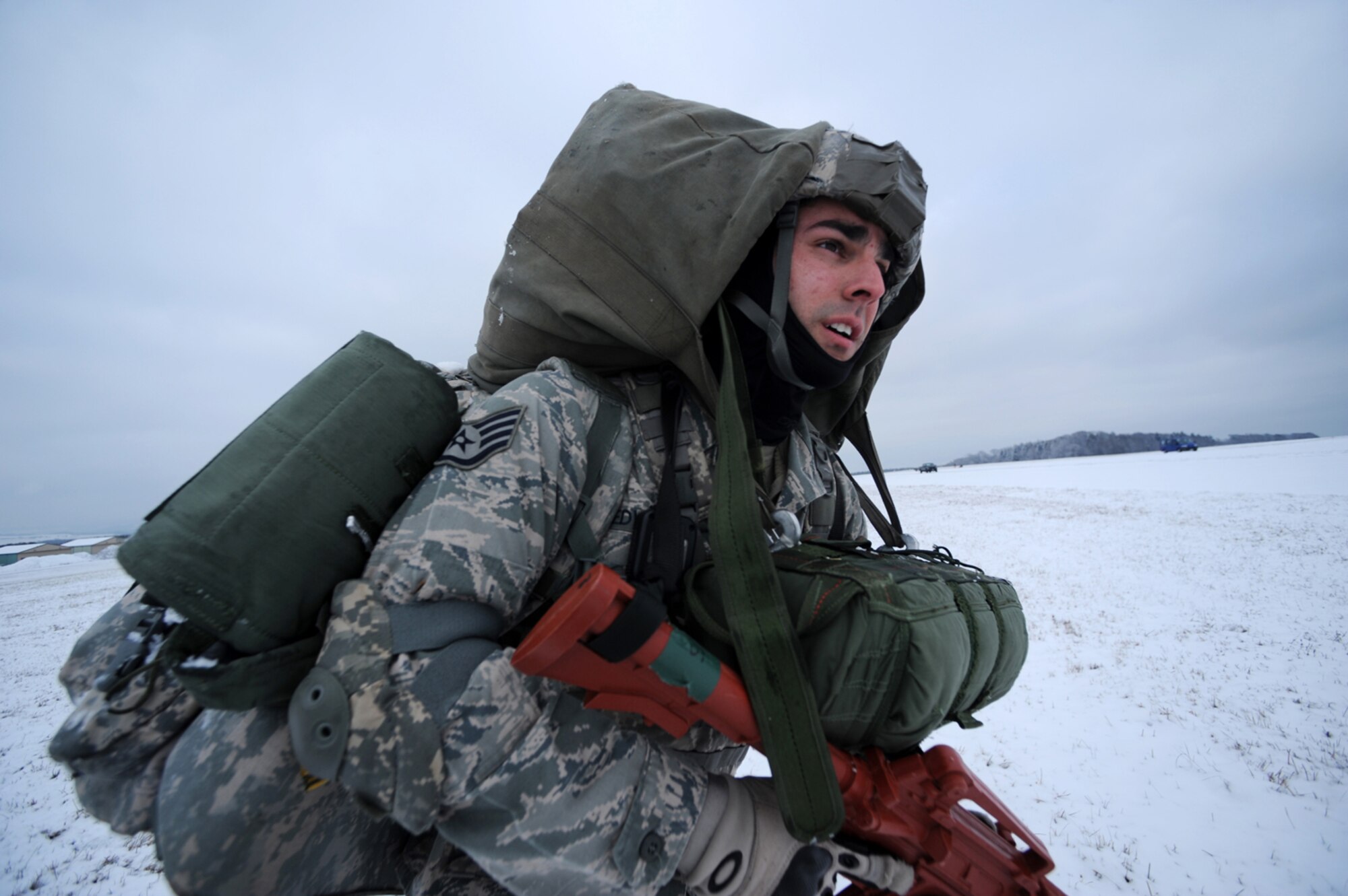 U.S. Air Force Staff Sgt. Dave Edwards, 435th Security Forces Squadron, Sembach Annex, Germany, maneuvers toward a rally point after an airborne insertion mission, Flugplatz Bitburg, Germany, Jan. 25, 2010, in preparation of Ramstein's operational readiness inspection in September. The unit is setting up bare-base operations as part of the dual-wing operational readiness exercise with the 86th Airlift Wing. This is the second of five operational readiness exercises. (U.S. Air Force photo by Staff Sgt. Sarayuth Pinthong)