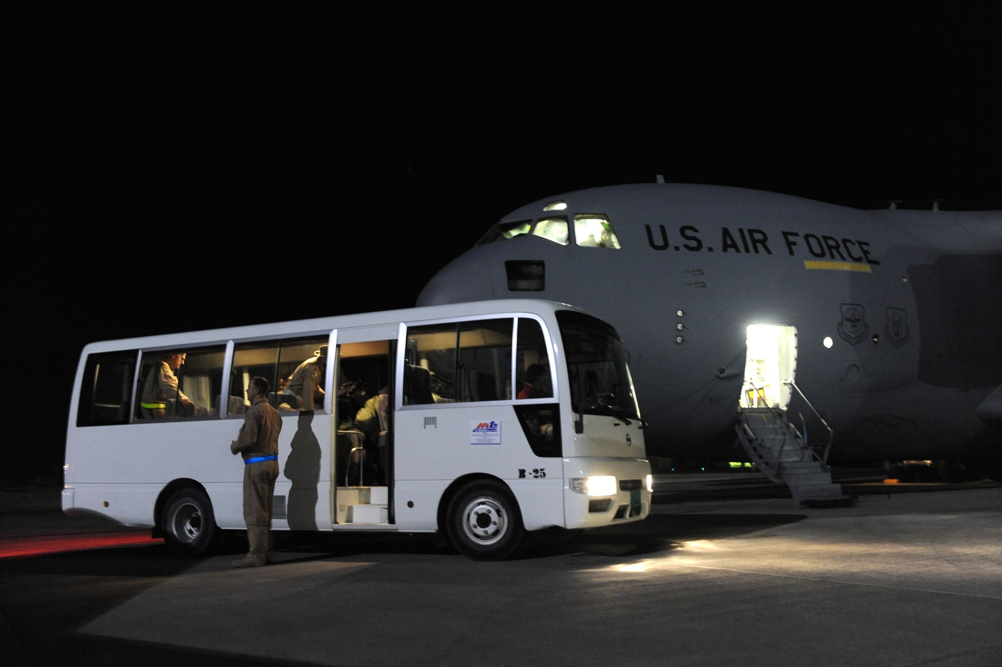 A C-17A Globemaster III aircrew assigned to the 816th Expeditionary Airlift Squadron step on a crew bus after a 13-hour cargo delivery mission to a forward operating base in Afghanistan, Jan. 20, 2010. (U.S. Air Force/Staff Sgt. Manuel J. Martinez)