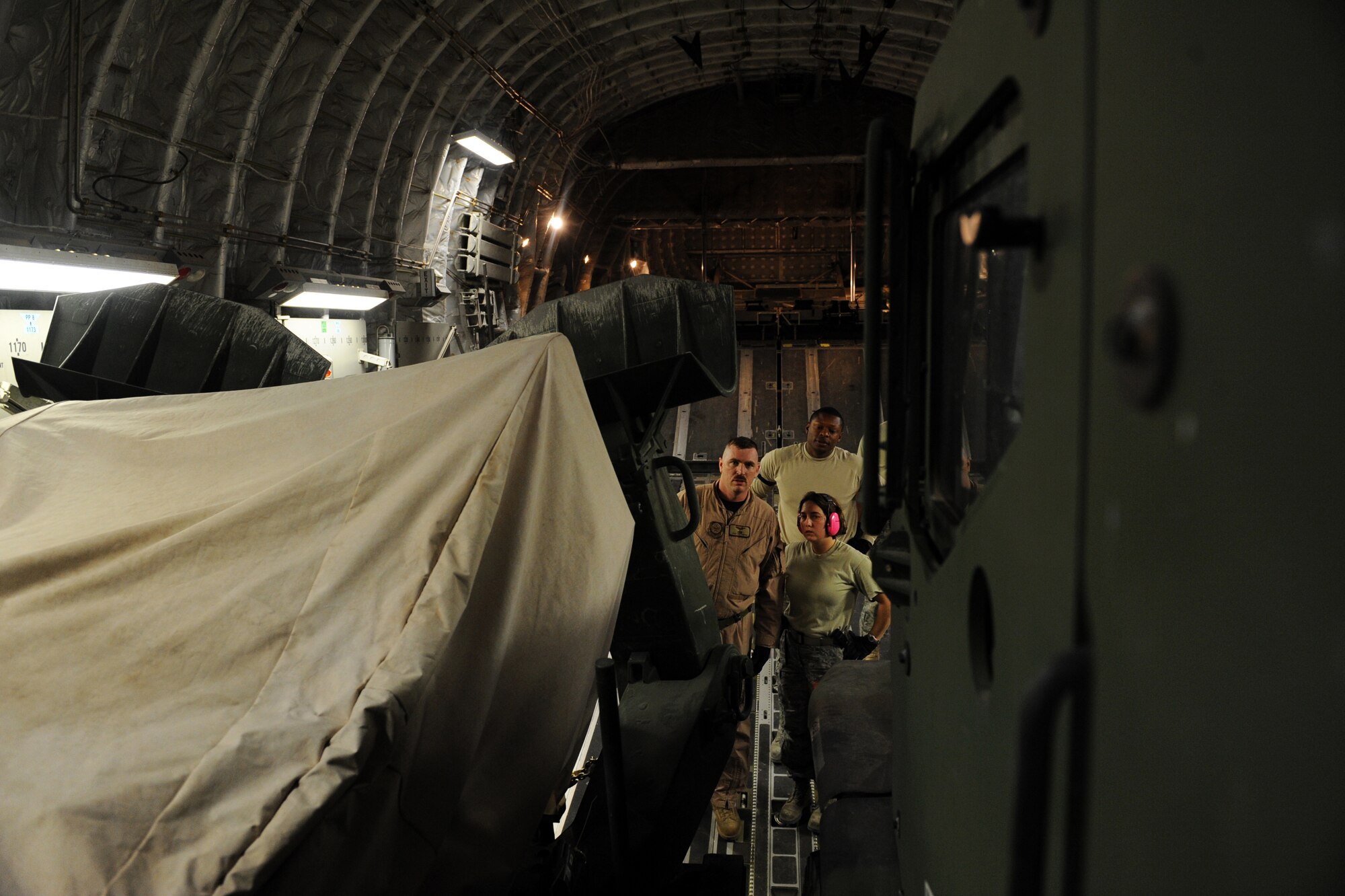 Tech. Sgts. Kevin M. Owens, Patricia Lapp and Senior Airman Kareen Brown inspect U.S. Marine Corps vehicles loaded into a C-17A Globemaster III, Jan. 20, 2010 at a base in Southwest Asia. The vehicles are part of a 95,000-pound cargo load being transported to a forward operation base in Afghanistan. Sergeant Owens is assigned to the 816th Expeditionary Airlift Squadron while Sergeant Lapp and Airman Brown are assigned to the 386th Expeditionary Logistics Readiness Squadron. (U.S. Air Force photo/Staff Sgt. Manuel J. Martinez)