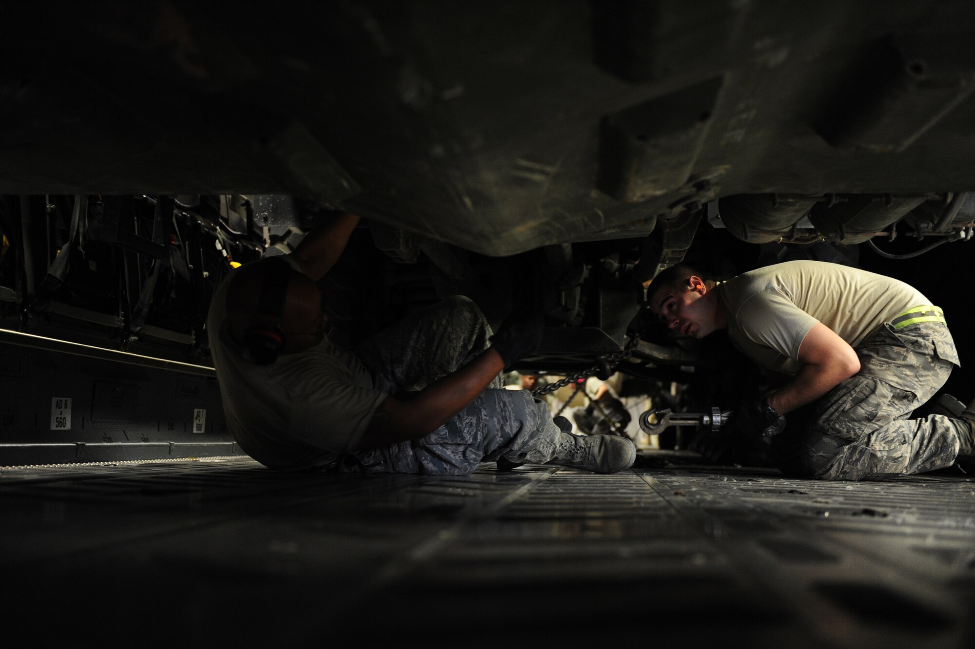 Tech. Sgt. Clarence Marshall (left) and Senior Airman Lee Ciokiewicz, both assigned to the 386th Expeditionary Logistics Readiness Squadron, secure a U.S. Marine Corps vehicle in the back of a C-17A Globemaster III Jan. 20, 2010, at a base in Southwest Asia. (U.S. Air Force photo/Staff Sgt. Manuel J. Martinez)
