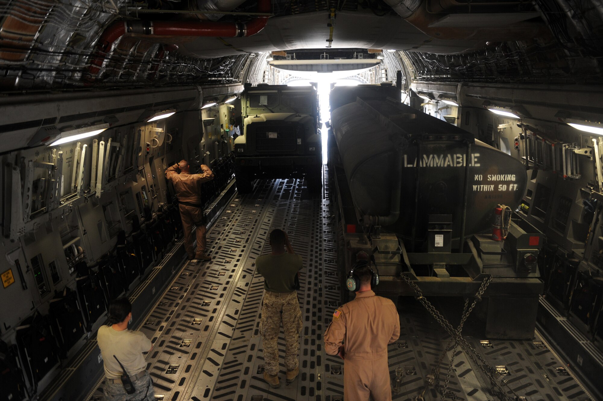Tech. Sgt. Kevin M. Owens, a C-17A Globemaster III loadmaster assigned to the 816th Expeditionary Airlift Squadron, guides a driver into the C-17 Jan. 20, 2010, at a base in Southwest Asia. (U.S. Air Force photo/Staff Sgt. Manuel J. Martinez)