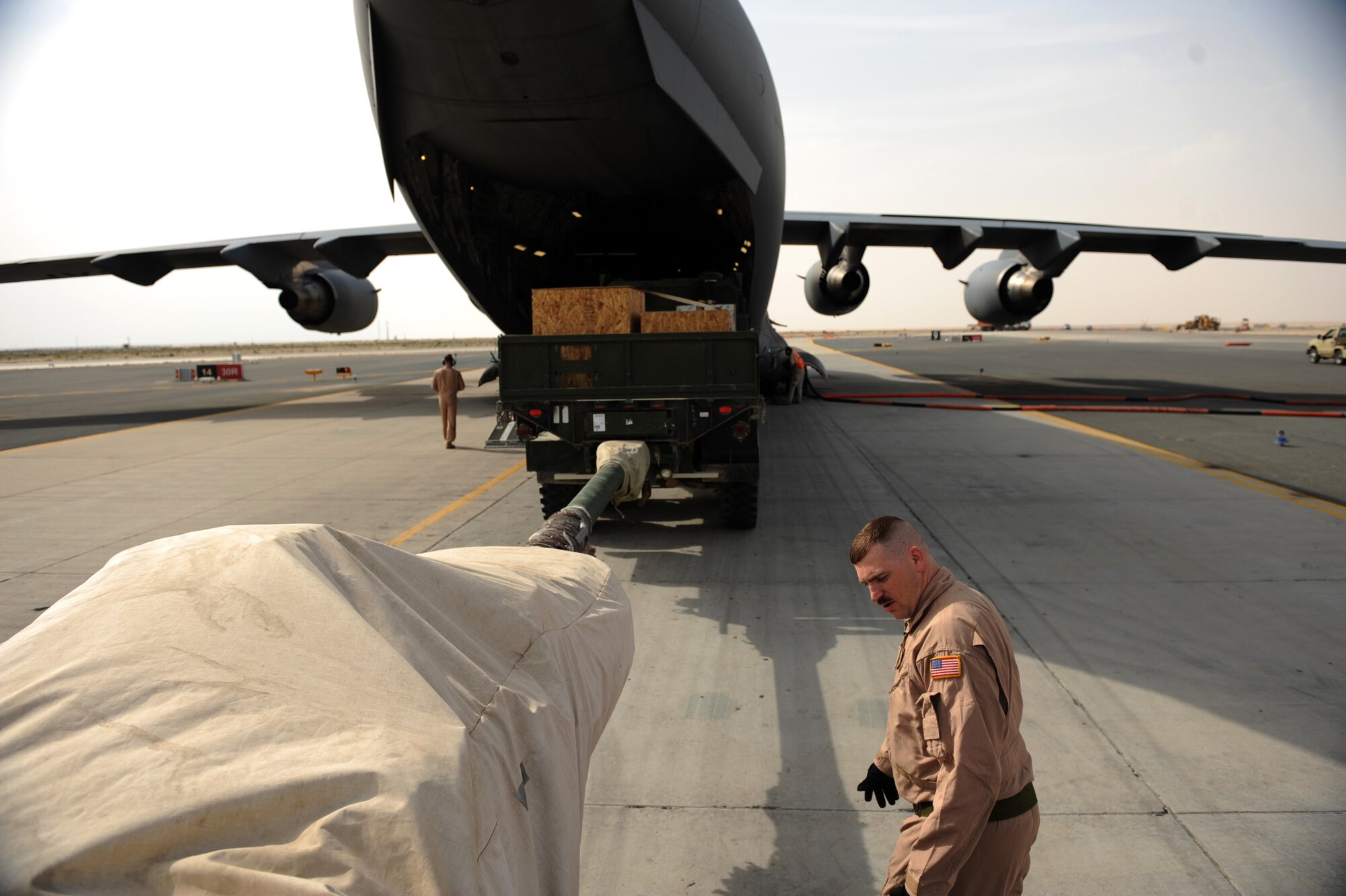 Tech. Sgt. Kevin M. Owens, a loadmaster assigned to the 816th Expeditionary Airlift Squadron, inspects a howizter as loading crews bring it aboard a C-17A Jan. 20, 2010, at a base in Southwest Asia.  (U.S. Air Force photo/Staff Sgt. Manuel J. Martinez)