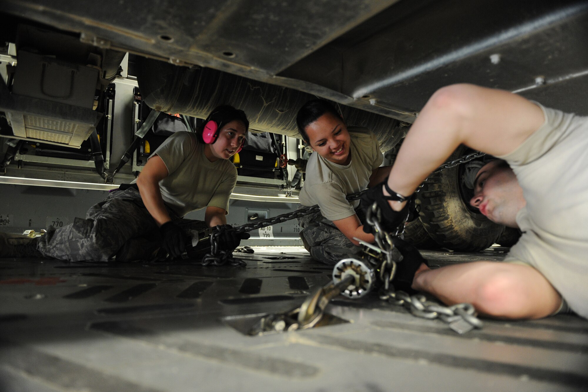 (From left) Tech. Sgt. Patricia Lapp, and Senior Airmen Danielle Bolia and Lee Ciokiewicz, assigned to the 386th Expeditionary Logistics Readiness Squadron, secure a U.S. Marine Corps vehicle on board a C-17A Globemaster III bound for Afghanistan, Jan. 20, 2010, at a base in Southwest Asia. (U.S. Air Force photo/Staff Sgt. Manuel J. Martinez)