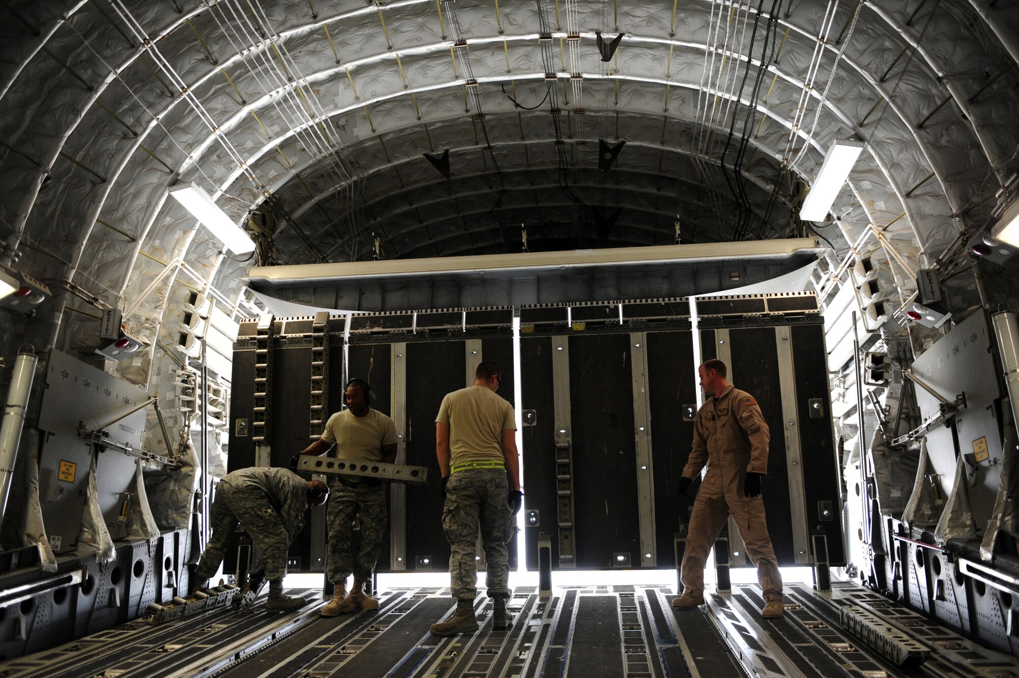 Senior Airman Anthony E. Fuller, (right) a loadmaster assigned to the 816th Expeditionary Airlift Squadron, and fellow Airmen prepare a C-17A Globemaster III to transport 95,000 pounds of cargo to Afghanistan, Jan. 20, 2010, at a base in Southwest Asia.  (U.S. Air Force photo/Staff Sgt. Manuel J. Martinez)
