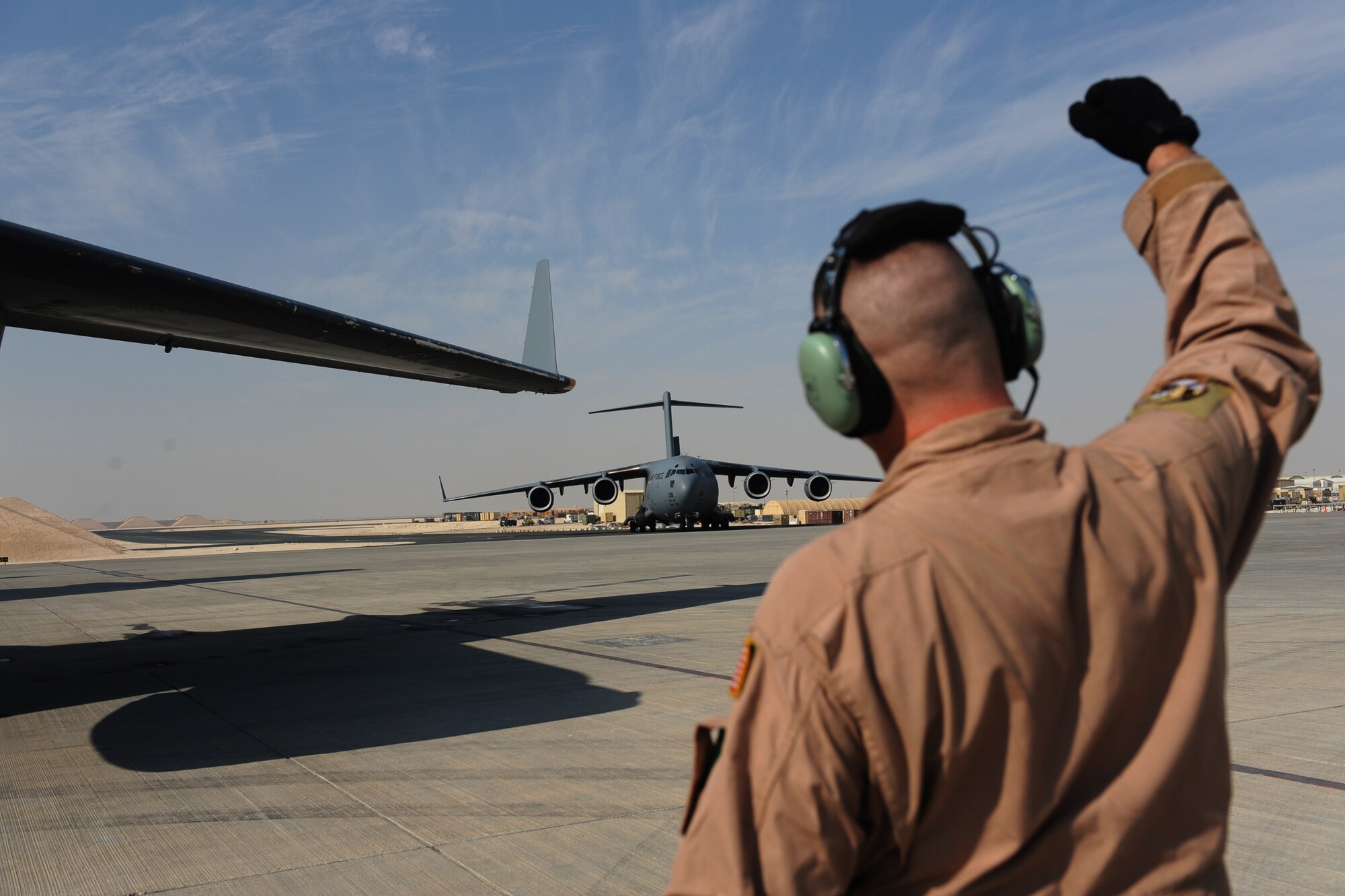 Tech. Sgt. Kevin M. Owens, a loadmaster from the 816th Expeditionary Airlift Squadron, observes a C-17A Globemaster III engine start-up and relays his observations to pilots using hand signals Jan. 20, 2010, at a forward operating base in Southwest Asia. The cargo transport mission is bound for a forward operating base in Afghanistan. (U.S. Air Force photo/Staff Sgt. Manuel J. Martinez)
)