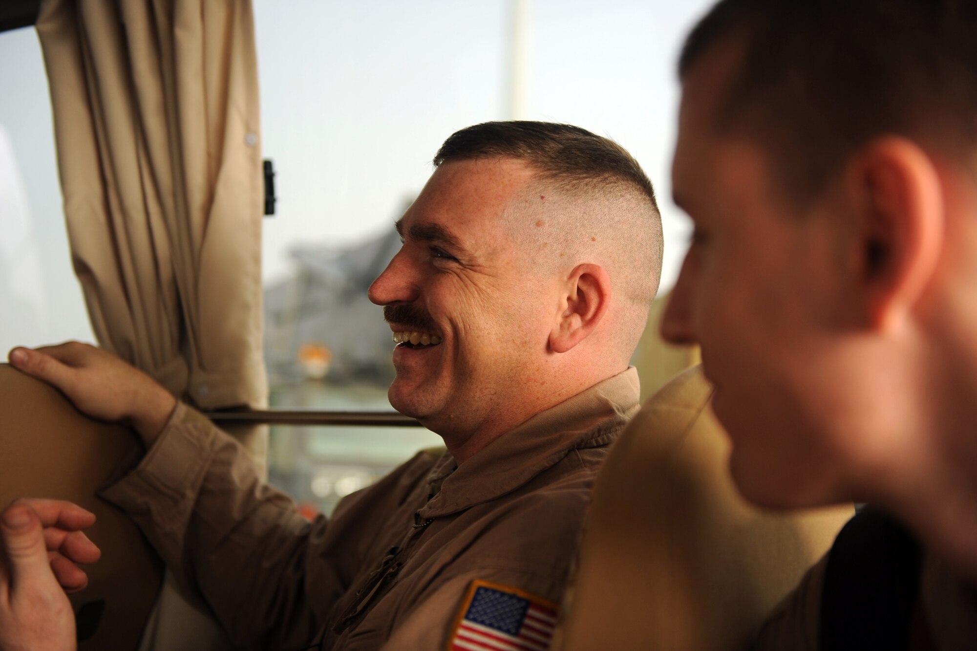 Tech. Sgt. Kevin M. Owens, (left) a loadmaster from the 816th Expeditionary Airlift Squadron, jokes with fellow aircrew members during a bus ride to their C-17A Globemaster III Jan. 20, 2010, at a forward operating base in Southwest Asia. (U.S. Air Force/Staff Sgt. Manuel J. Martinez)