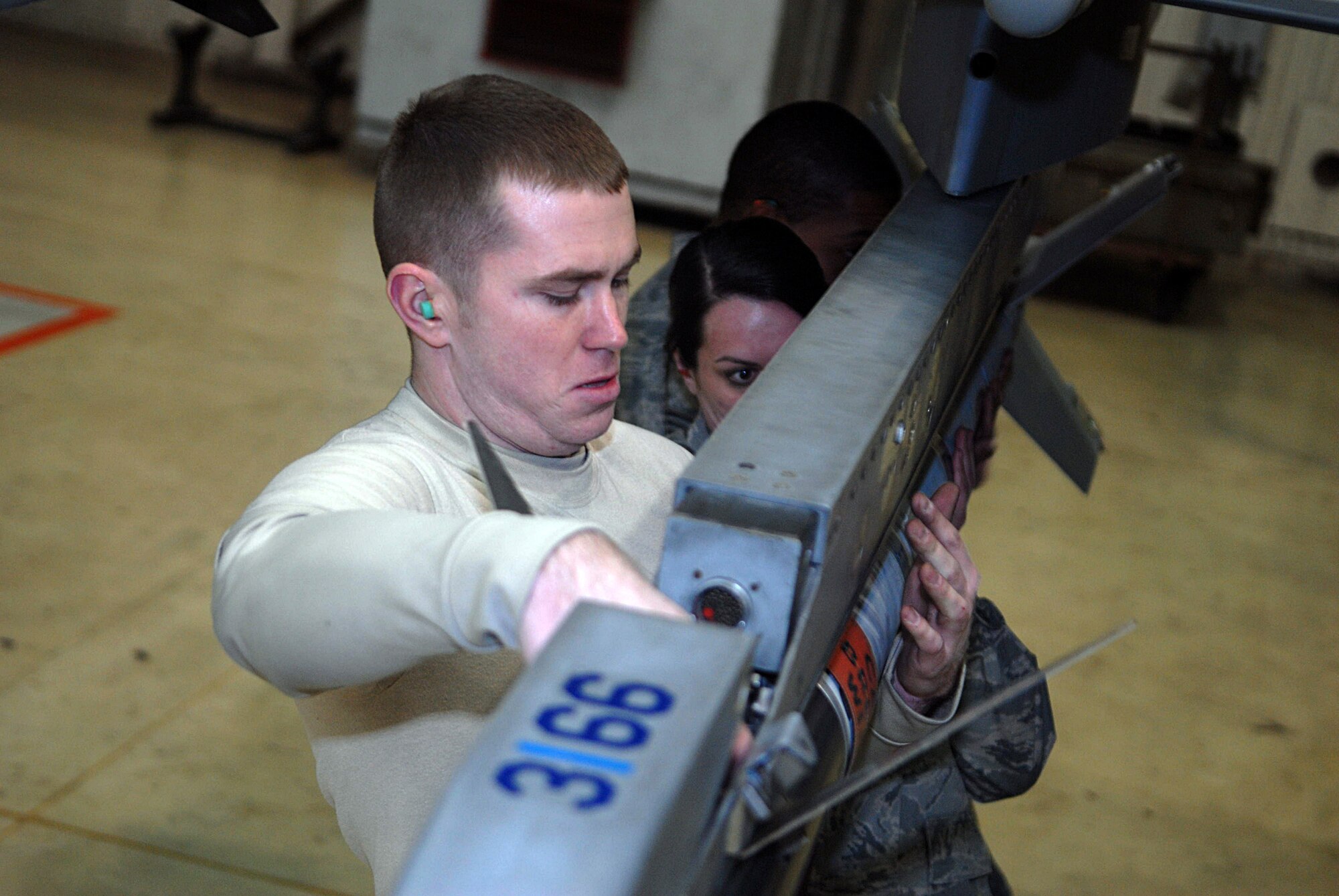KUNSAN AIR BASE, Republic of Korea -- Senior Airman Jesse Tannehill, Staff Sgt. Jennifer Diana and Senior Airman Tyrell Harris all 8th Aircraft Maintenance Squadron weapons load crew members, secures ammunition on an F-16 Fighting Falcon during a weapons load competition Jan. 22. The best load crews from the 35th Aircraft Maintenance Unit and 80th Aircraft Maintenance Unit compete in a weapons load competition every month to maintain proficiency in weapon loading. (U.S. Air Force photo/Senior Airman Roy Lynch)