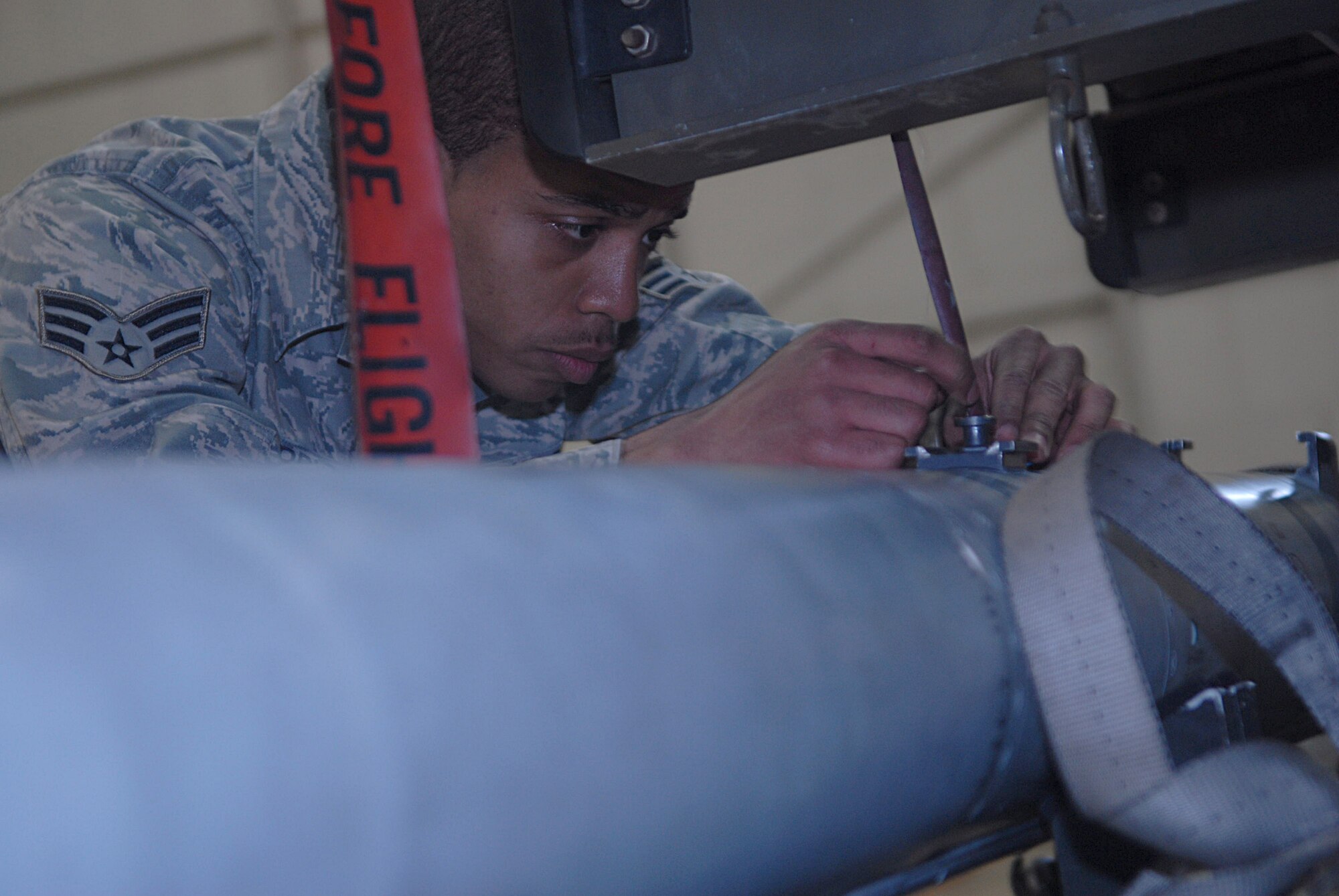 KUNSAN AIR BASE, Republic of Korea -- Senior Airman Tyrell Harris, 8th Aircraft Maintenance Squadron weapons load crew member, preps a munition for an F-16 Fighting Falcon during a weapons load competition Jan. 22. The best load crews from the 35th Aircraft Maintenance Unit and 80th Aircraft Maintenance Unit compete in a weapons load competition every month. (U.S. Air Force photo/Senior Airman Roy Lynch)