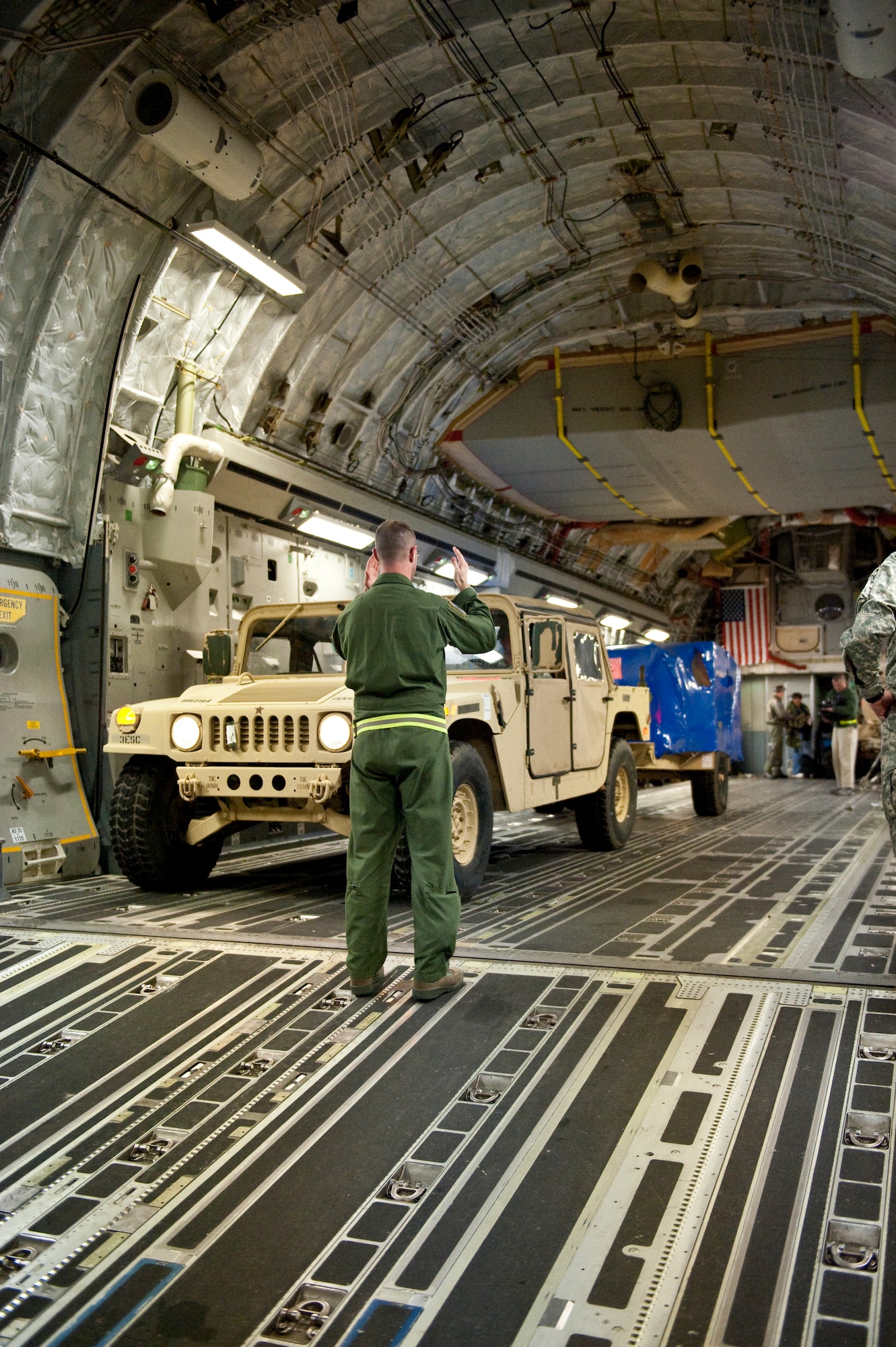 Air Force Tech. Sgt. Cecil Dickerson, a loadmaster from the Alaska Air National Guard?s 249th Airlift Squadron, directs an Army Humvee onto a Mississippi Air National Guard C-17 aircraft at the Kentucky Air National Guard Base in Louisville, Ky., on Jan. 27, 2010. The Humvee, along with 90 tons of other equipment and about 40 soldiers from the 3rd Sustainment Command (Expeditionary), were deploying to Port-au-Prince, Haiti, for earthquake relief efforts as part of Operation Unified Response. The Fort Knox, Ky.-based unit is expected to stay in Haiti for up to six months. (U.S. Air Force photo by Maj. Dale Greer/Released)