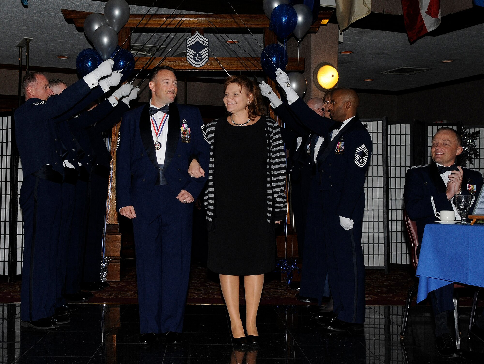 Senior Master Sgt. Greg Henaire, 18th Communications Squadron, and his wife, Nicole, walk through sabers raised by his new peers during Kadena’s chief recognition ceremony at the Rocker NCO Club Jan. 23. Nearly 250 friends, family and coworkers celebrated the achievements of 13 Air Force and Japan Air Self Defense Force senior NCOs as they sew on the enlisted force's highest rank. (U.S. Air Force photo by Staff Sgt. Chrissy Best)