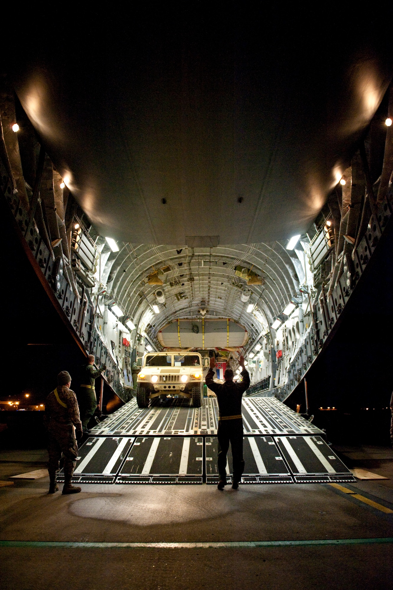 Air Force Tech. Sgt. Cecil Dickerson, a loadmaster from the Alaska Air National Guard?s 249th Airlift Squadron, directs an Army Humvee onto a Mississippi Air National Guard C-17 aircraft at the Kentucky Air National Guard Base in Louisville, Ky., on Jan. 27, 2010. The Humvee, along with 90 tons of other equipment and about 40 soldiers from the 3rd Sustainment Command (Expeditionary), were deploying to Port-au-Prince, Haiti, for earthquake relief efforts as part of Operation Unified Response. The Fort Knox, Ky.-based unit is expected to stay in Haiti for up to six months. (U.S. Air Force photo by Maj. Dale Greer/Released)