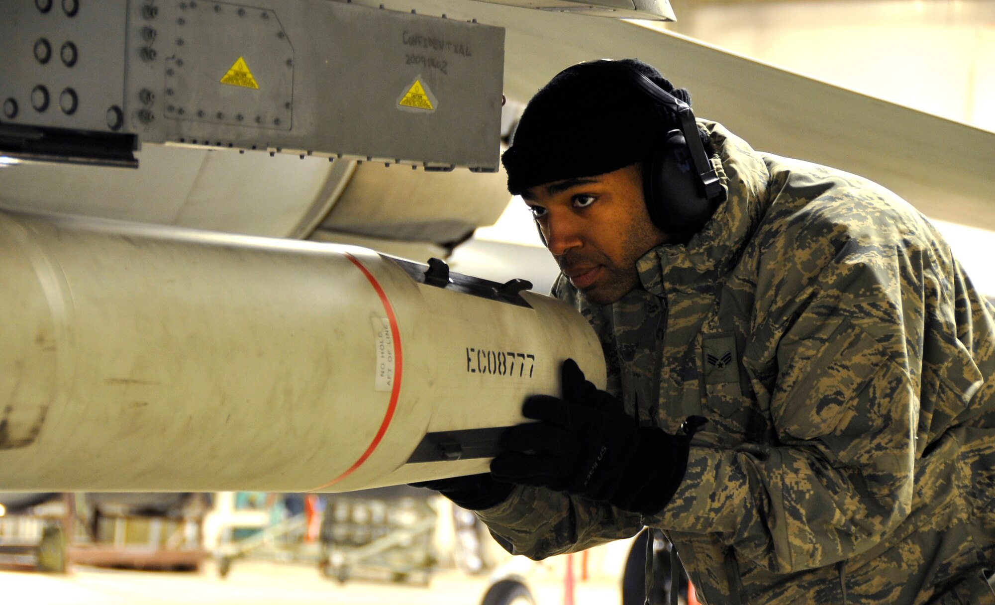 MISAWA AIR BASE, Japan -- Senior Airman Julian Mason, 35th Aircraft Maintenance Unit weapons loadcrew member, aligns an air-to-ground 88 missile on a weapons pylon during exercise Beverly Sunrise 10-01 Jan. 27. During the exercise, weapons loadcrew professionals will be loading a variety of weapons to fulfill mission requirements. (U.S. Air Force Photo/Staff Sgt. Chad C. Strohmeyer)