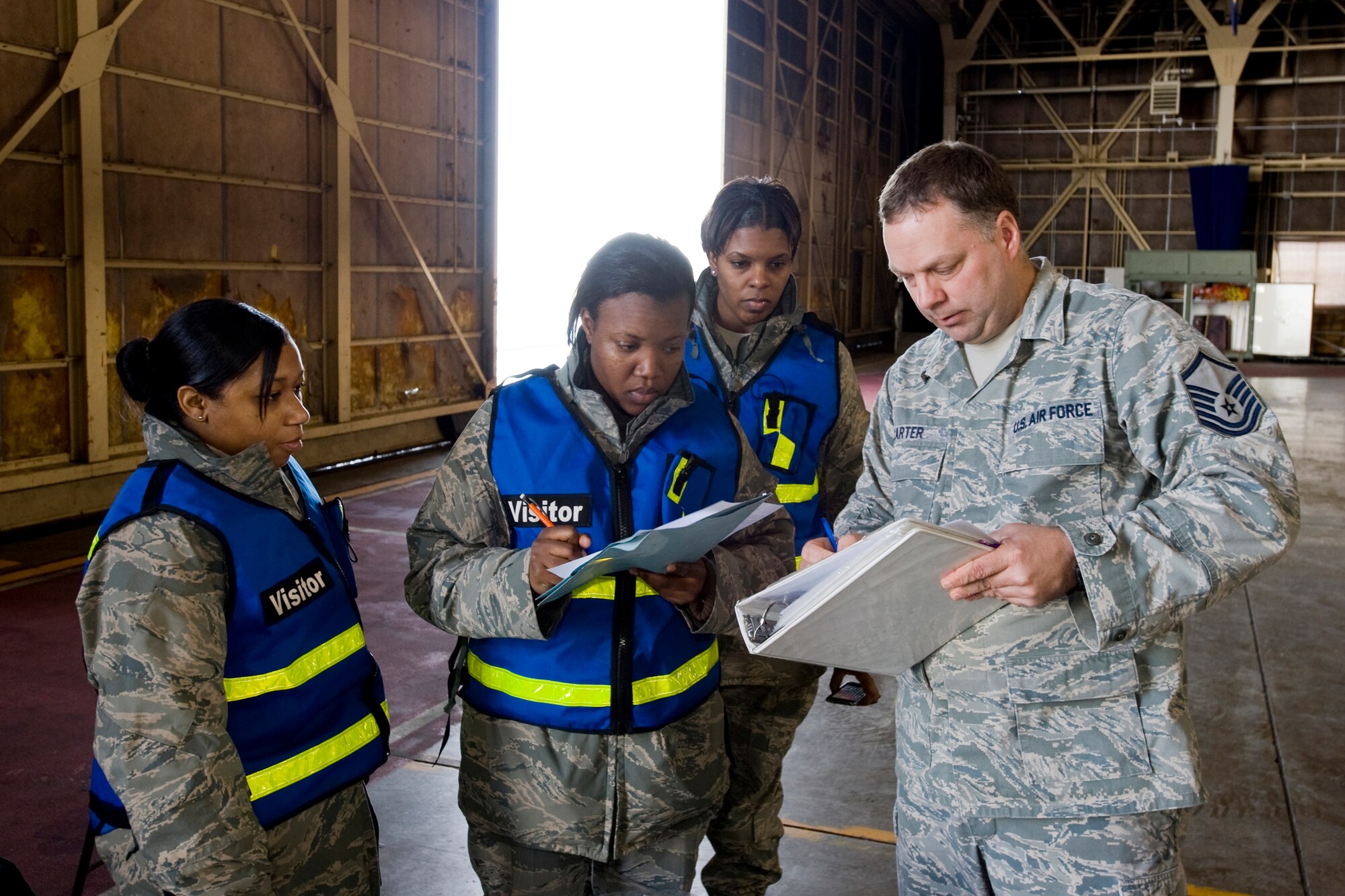 MISAWA AIR BASE, Japan -- Master Sgt. John Carter, 35th Logistics Readiness Squadron cargo deployment function log planner, reviews paperwork with Airman 1st Class April Paulk, Staff Sgt. Antonia Lilly and Staff Sgt. Mari Richardson during an operational readiness exercise Jan. 27. Airman Paulk and Sergeants Lilly and Richardson are part of a team that ensures deployment kits are free of discrepancies and ready to ship. (U.S. Air Force photo/Senior Airman Jamal D. Sutter)
