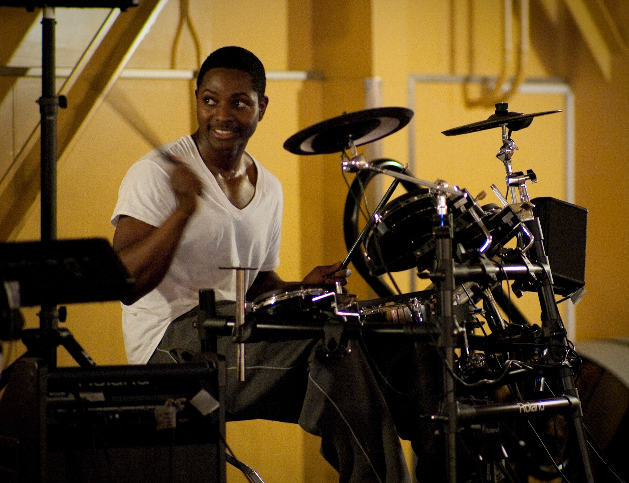 MISAWA AIR BASE, Japan -- Airman 1st Class Jamal Golden, 373rd Support Squadron conventional systems maintainer, discusses the drum beat for his next song with fellow band members Jan. 23 at the Airman's Center. The new Airman's Center features a stage with state-of-the-art electronic instruments such as an electronic drum set and digital stage piano. (U.S. Air Force photo/Staff Sgt. Samuel Morse)