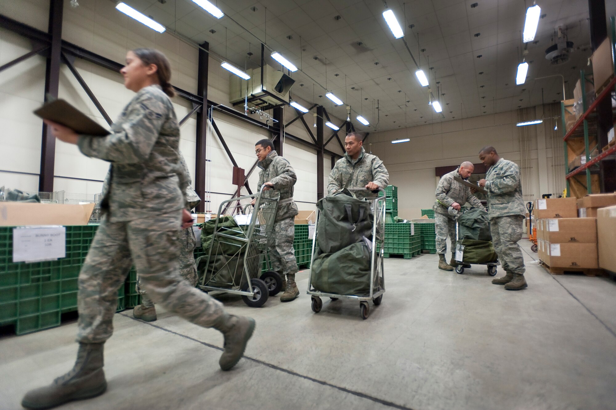 MISAWA AIR BASE, Japan -- 35th Logistics Readiness Squadron augmentees issue cold weather equipment bags during an operational readiness exercise in the supply warehouse Jan. 27. Each of the 143 initial mock deployers were issued individual protective equipment for nuclear, biological and chemical attacks, as well as cold weather and general purpose items. (U.S. Air Force photo/Staff Sgt. Samuel Morse)