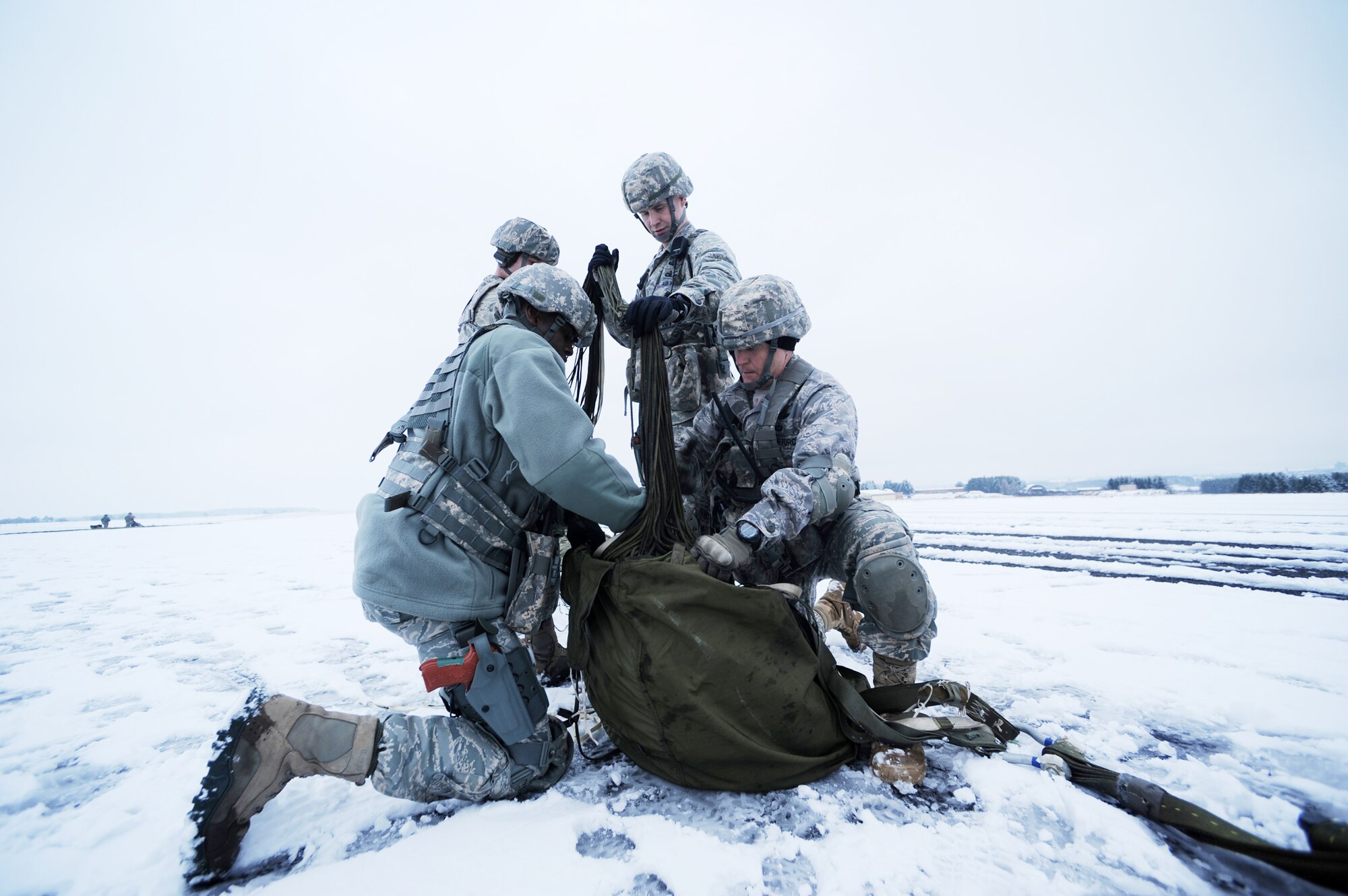 Airmen from the 435th Security Forces Squadron at Ramstein Air Base, Germany, secure equipment parachutes at nearby Bitburg Airport, Jan. 25, 2010, in preparation of Ramstein's operational readiness inspection in September. The unit is setting up bare-base operations as part of the dual-wing operational readiness exercise with the 86th Airlift Wing.   (U.S. Air Force photo/Staff Sgt. Sarayuth Pinthong)