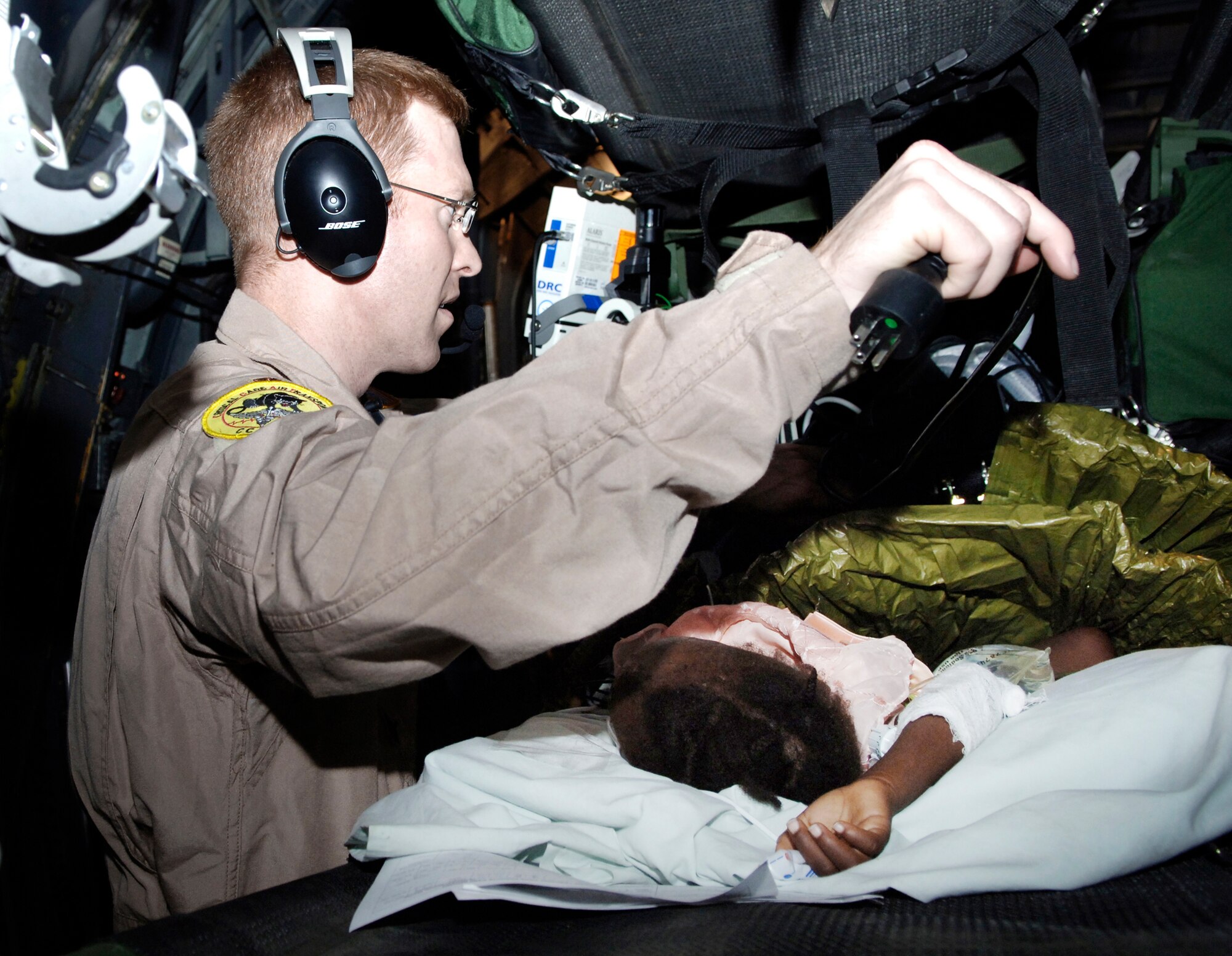 Maj. John Lynch, a physician and critical care air transport team member, prepares a 3-year-old earthquake victim for aeromedical evacuation from Port-au-Prince, Haiti, to Fort Lauderdale, Fla., Jan. 24, 2010.  Major Lynch is with the 88th Medical Group from Wright-Patterson Air Force Base, Ohio. (U.S. Air Force photo/2nd Lt. Anastasia Wasem)