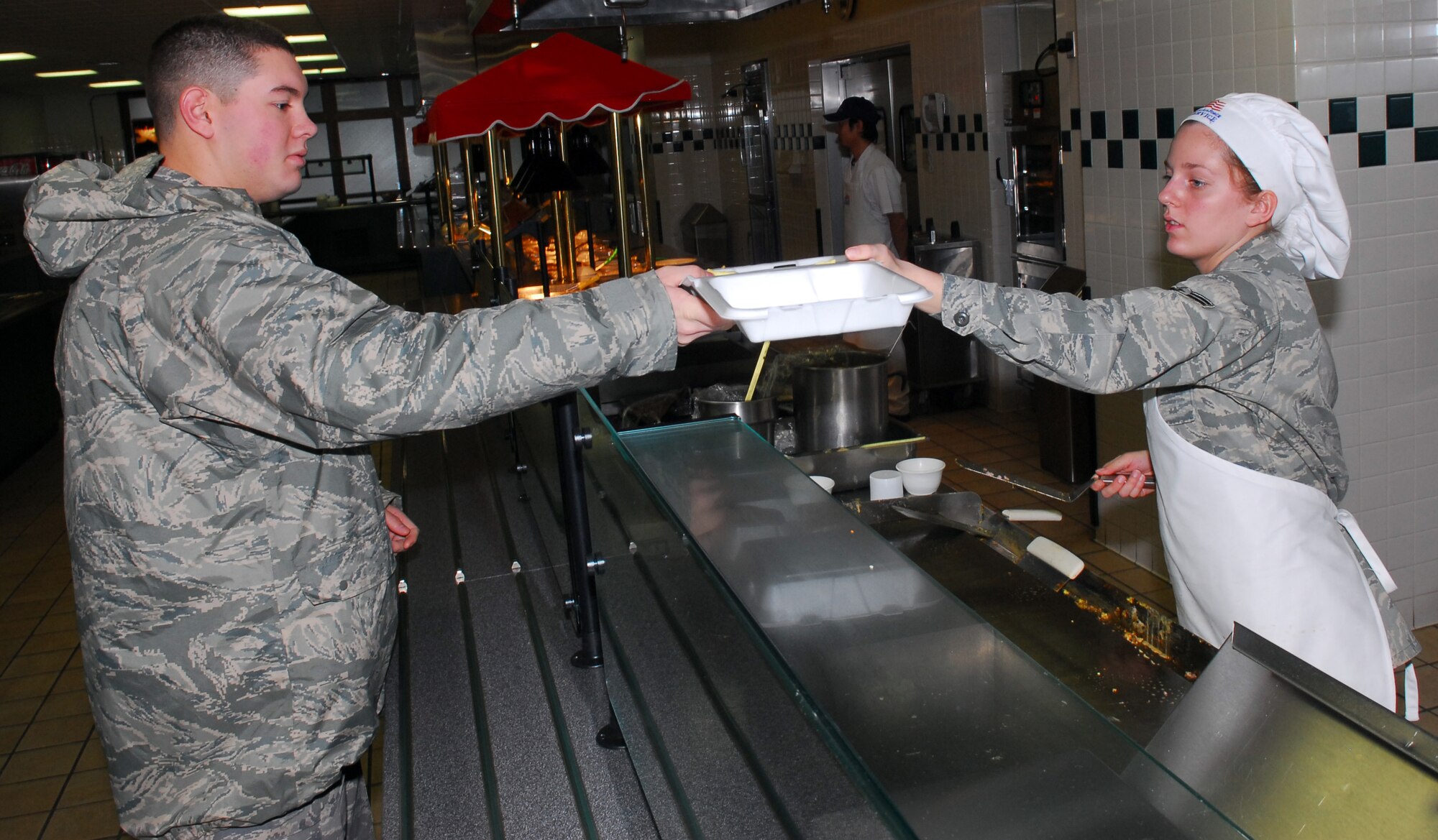 MISAWA AIR BASE, Japan – Airman 1st Class Whitney Massey, 35th Force Support Squadron Grissom Dining Facility line cook, hands Airman 1st Class Robert Wesson, 35th Civil Engineer Squadron heating and air conditioning apprentice, his breakfast Jan. 26 at the Grissom Dining Facility. The DFAC will operate at regular hours during exercise Beverly Sunrise 10-01. (U.S. Air Force photo/Staff Sgt. Phillip Butterfield)

