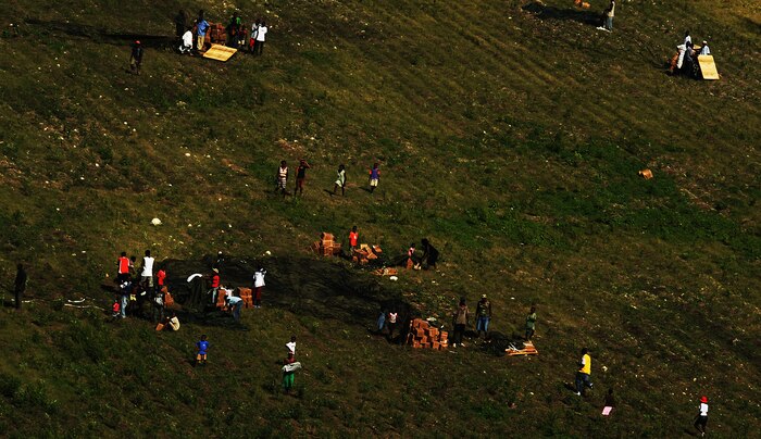 Haitians collect bottles of water and rations of food air delivered by a Charleston AFB C-17 Globemaster III aircraft Jan. 23, 2010, in the outlying area of Port-au-Prince, Haiti. The mission was flown as part of Operation Unified Response to save lives and bring relief to suffering people in Haiti. (U.S. Air Force photo by Tech. Sgt. James L. Harper Jr./Released)