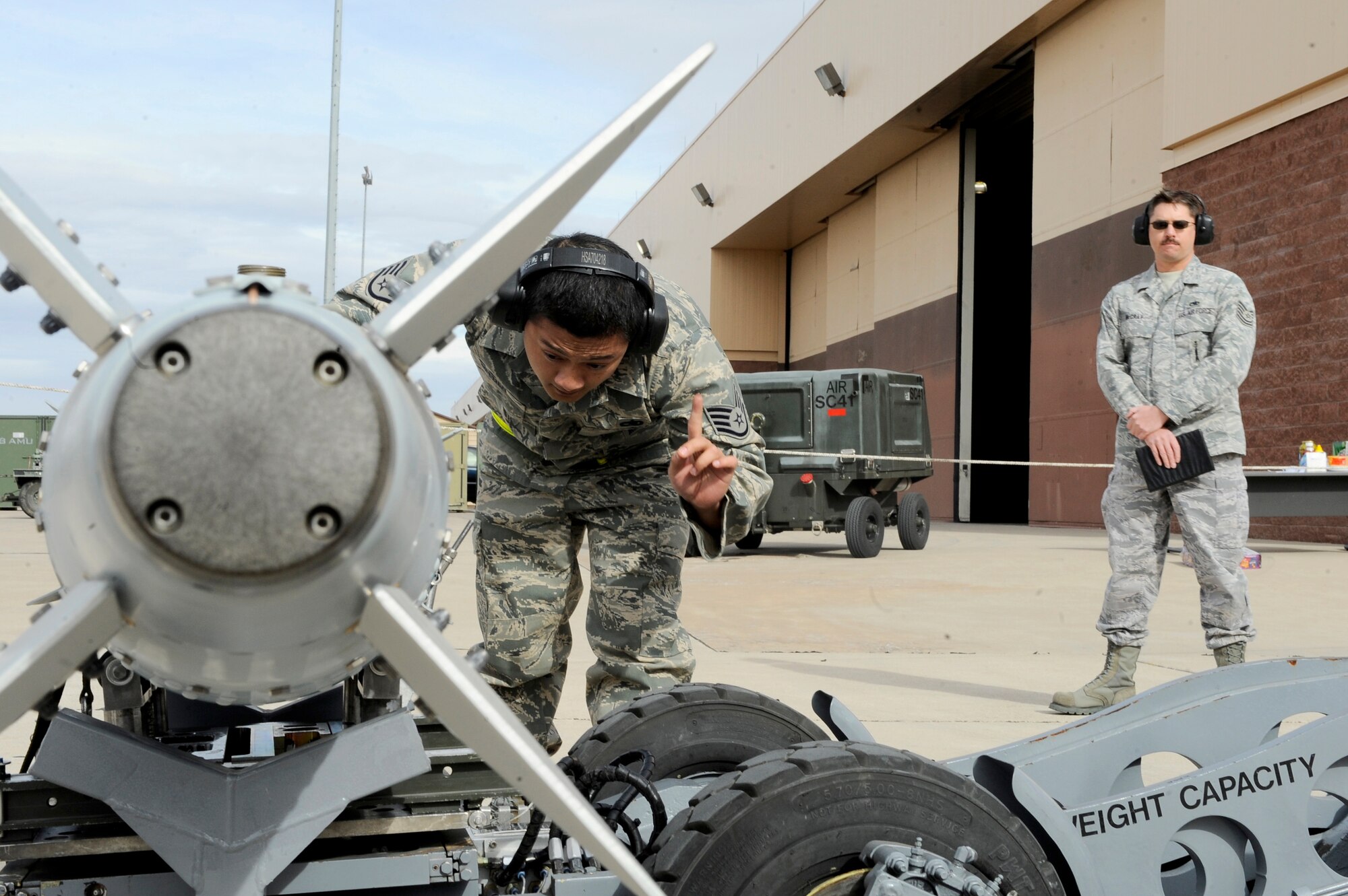 HOLLOMAN AIR FORCE BASE, N.M. -- Staff Sgt. Mario Belber, 49th Aircraft Maintenance Squadron, double checks his work during the Load Crew of the Year competition, Jan. 19, as inspector, Tech. Sgt. Robert McCray, 49th Maintenance Squadron, looks on. Sergeant Herber was part of a three-man team competing for the title of Load Crew of the Year on the F-22 Raptor. (U.S. Air Force photo by Airman 1st Class Veronica Stamps)