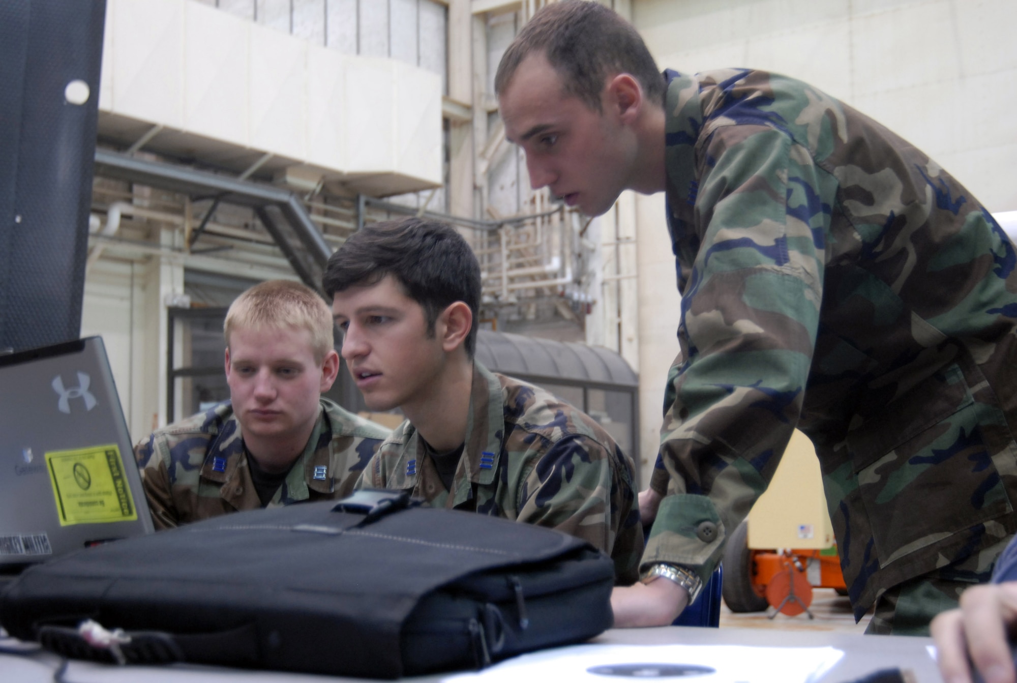 (From left to right) U.S. Air Force Academy Cadets Matthew Knutson, Joseph Ulisse, and Bill Percoski study data from FalconSAT-5 tests at the Air Force Research Lab at Edwards Jan 21. According to a U.S. Air Force Academy Department of Astronautics press release, the primary mission of the FalconSAT-5 is to perform space weather measurements with on-board sensors in collaboration with remote ground sites.   (Air Force photo/2nd Lt Belena Marquez)