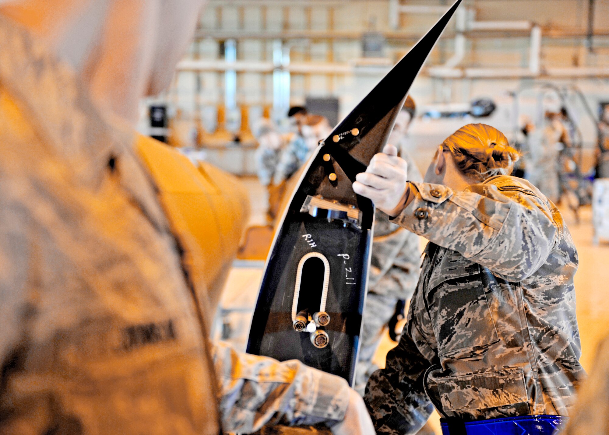 Senior Airman Stephanie Groome assists with placing the right wing of the MQ-1 Predator into a casket for transportation, Jan. 17, 2010, at Holloman Air Force Base, N.M. Airmen disassembled and packaged a Predator for departure in support of Operation Unified Response. Airman Groome is a crew chief assigned to the 849th Aircraft Maintenance Squadron. (U.S. Air Force photo/Staff Sgt. Anthony Nelson Jr.)
