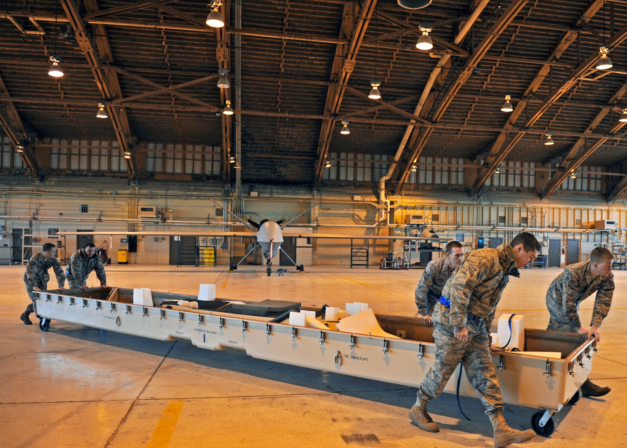 Airmen from the 849th Aircraft Maintenance Squadron push a casket across the hangar Jan. 17, 2010 at Holloman Air Force Base, N.M. The Airmen disassembled and packaged an MQ-1 Predator for departure in support of Operation Unified Response. (U.S. Air Force photo/Staff Sgt. Anthony Nelson Jr.)