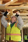 MINOT AIR FORCE BASE, N.D. -- Parker Lipetzky, a construction worker, performs electrical rough-in work in base housing here Jan. 27. Rough-in refers to the rough installation of the electrical wiring, boxes, fixture mounts and breaker panel and occurs after framing is completed and before drywall is installed. (U.S Air Force photo by Senior Airman Sharida Jackson)
