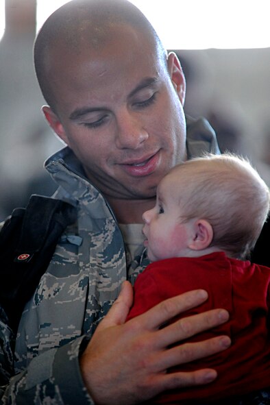 ELLSWORTH AIR FORCE BASE, S.D. -- Airman 1st Class Jordan Linial, 28th Aircraft Maintenance Squadron aircraft armament systems technician, holds his baby for the first time, Jan. 27. Airman Linial met his daughter after returning from his six-month deployment to Southwest Asia. (U.S. Air Force photo/Airman 1st Class Matthew Flynn)